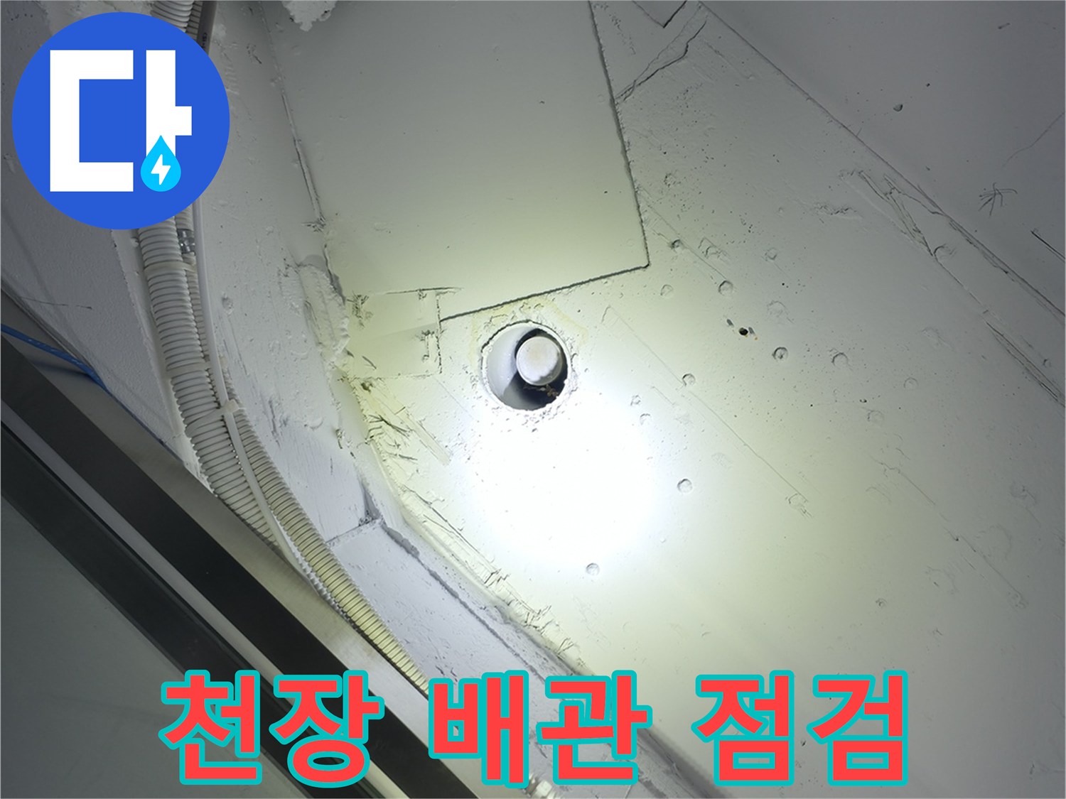 천장 내부의 노출된 배관과 전선관 상태를 확인하는 모습