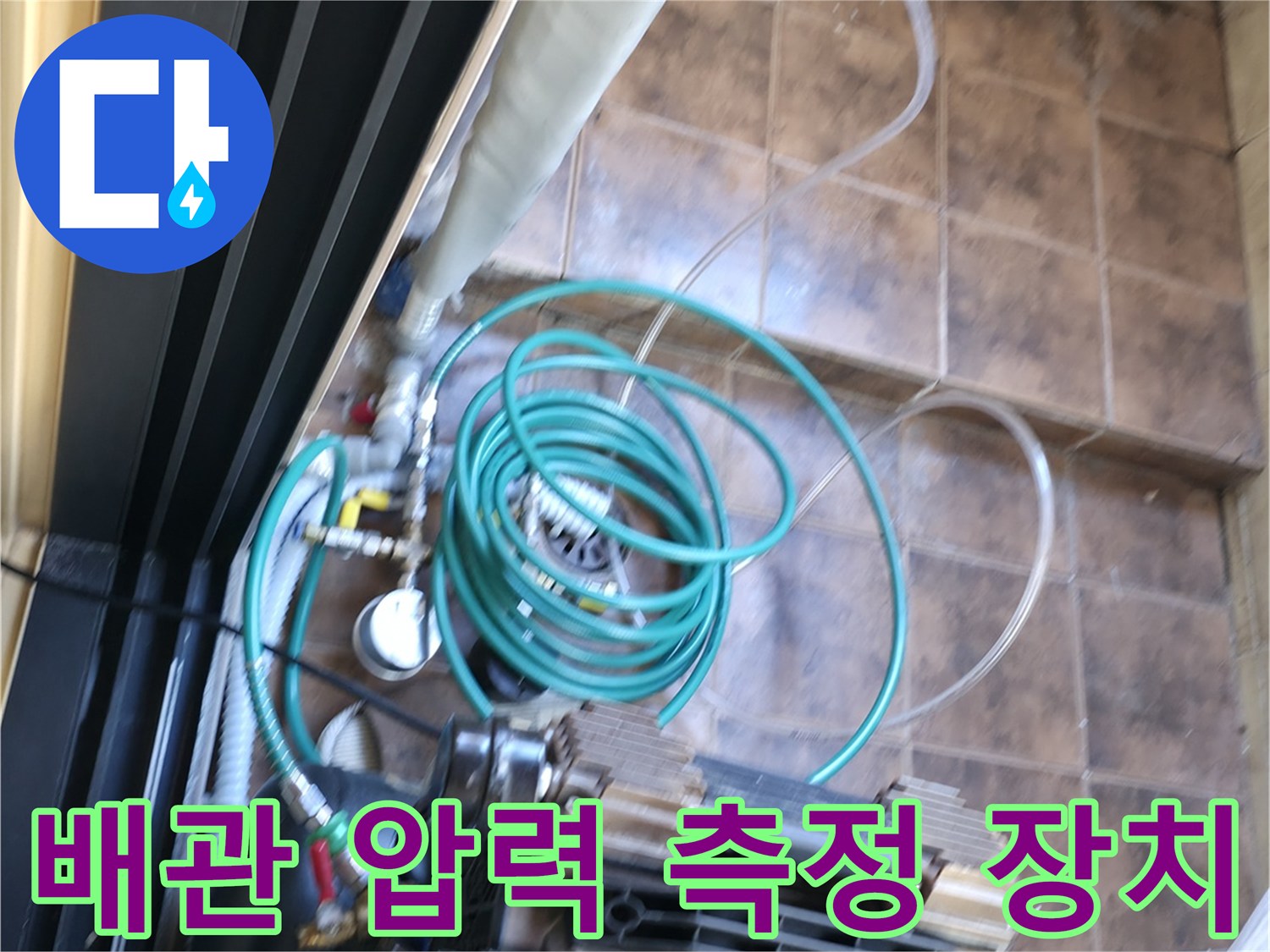 타일 바닥에 설치된 공기 압입용 호스와 압력계 연결 상태