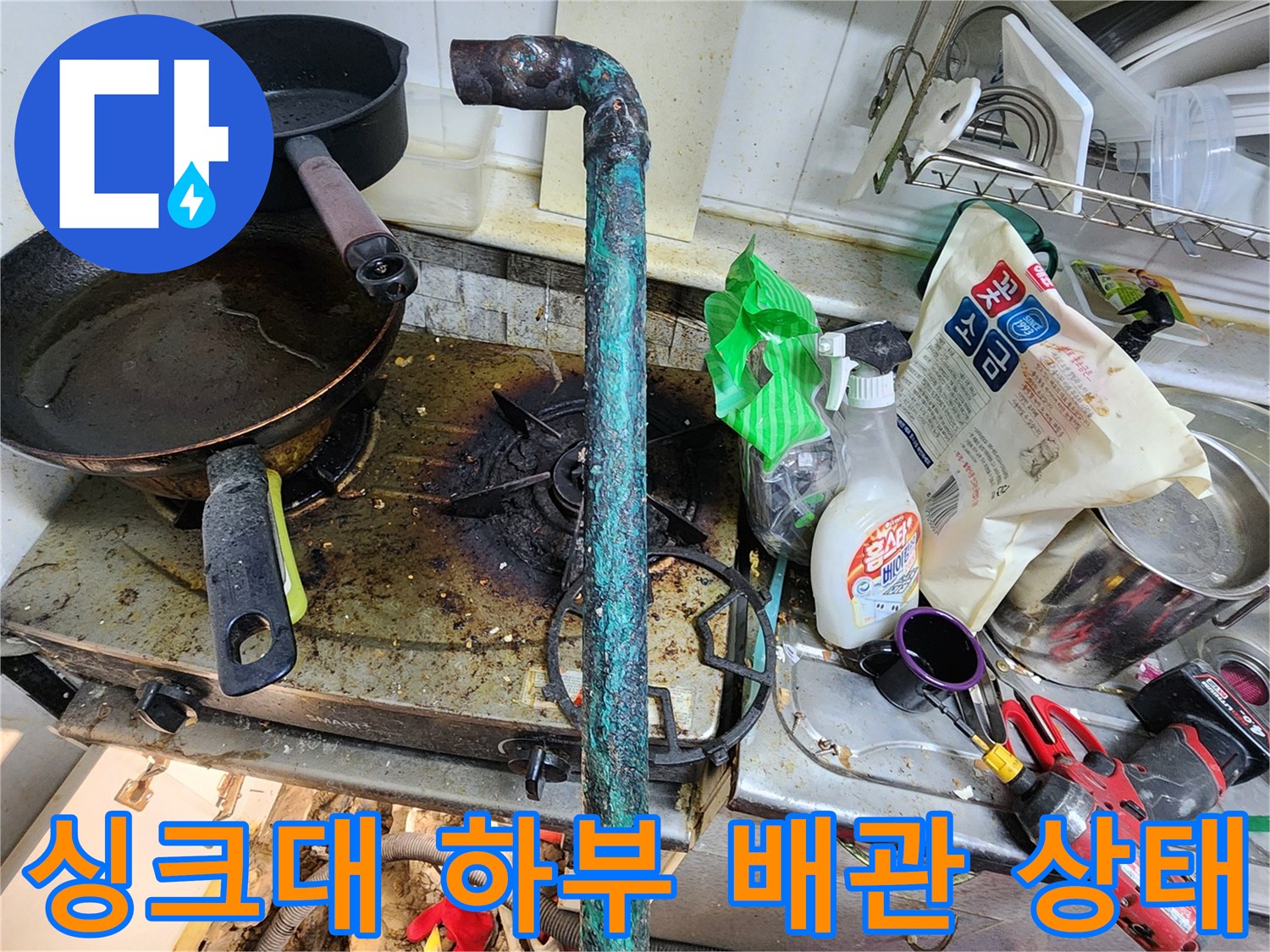 싱크대 하부-노후된 금속 배관과 작업 도구들