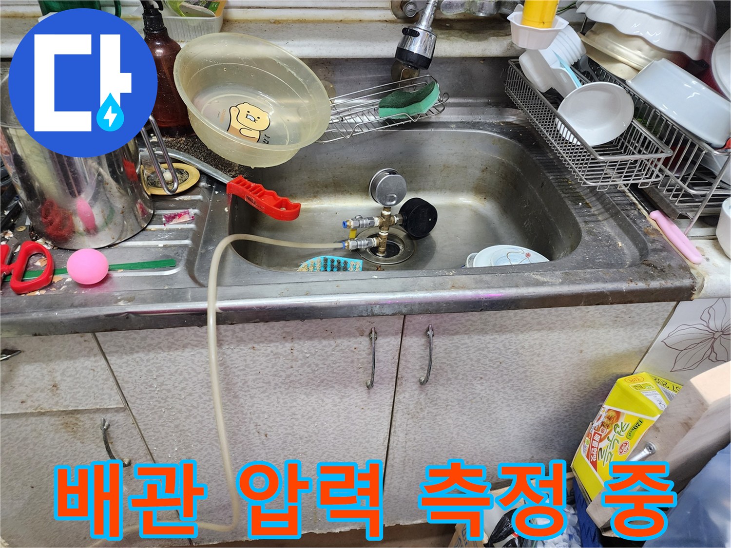 싱크대 하부 배관에 설치된 공압 게이지와 장비들
