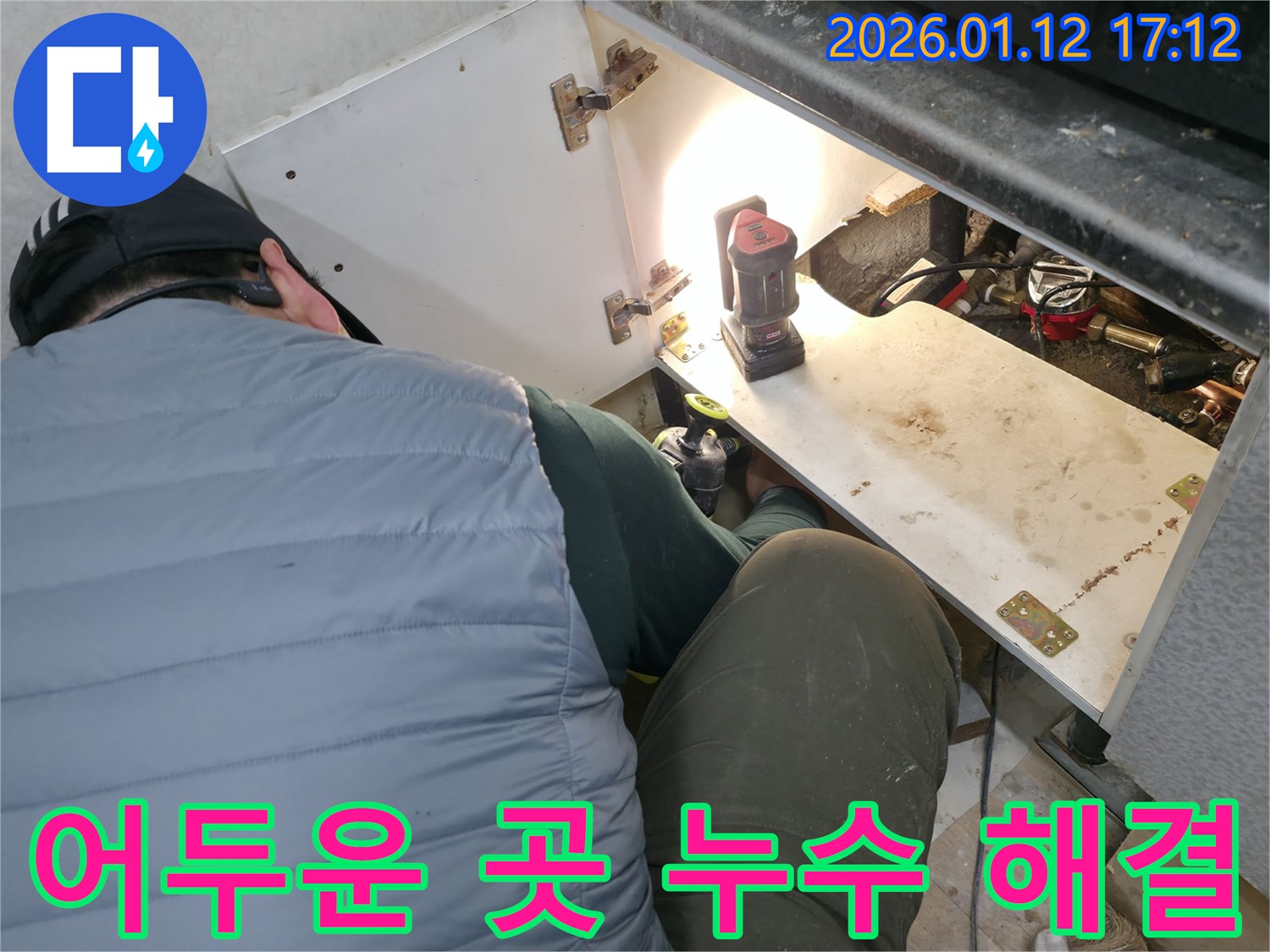 어두운 싱크대 하부에서 LED 조명을 사용하여 - 누수 지점을 밝혀내고 해결하는 모습