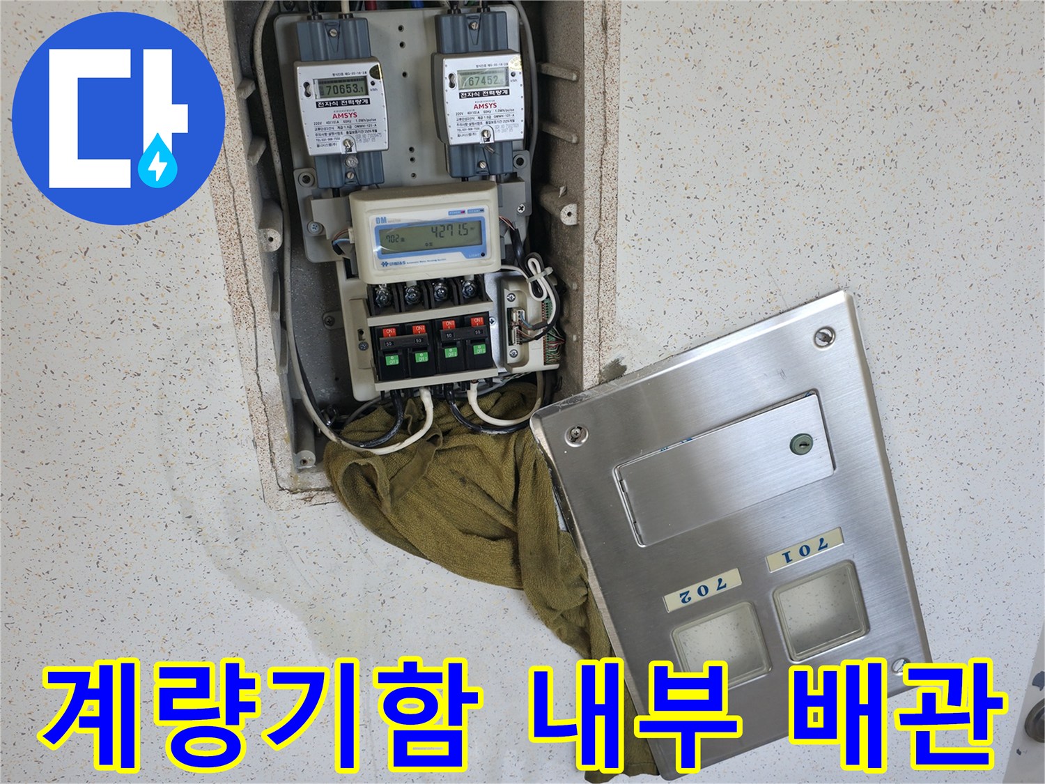 아파트 계량기함 내부에 노출된 배관과 밸브들의 연결 상태를 보여줍니다.