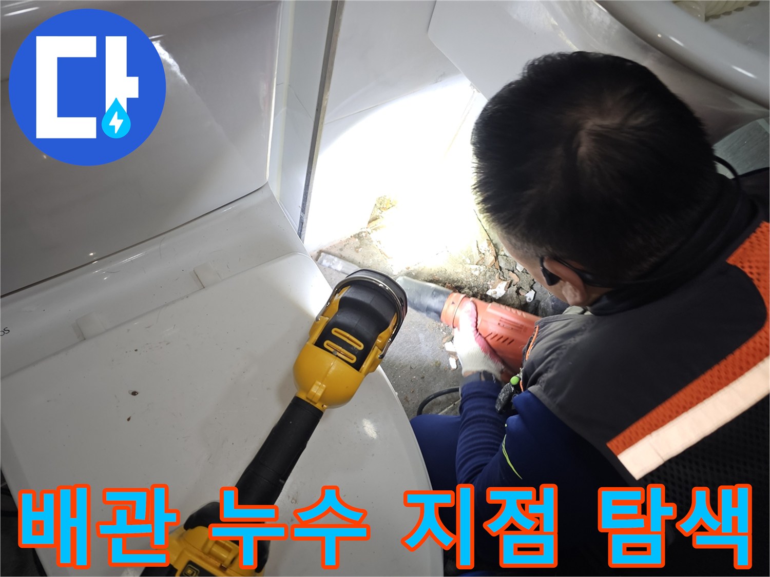 랜턴을 사용하여 어두운 배관 틈새를 조사하는 엔지니어의 모습