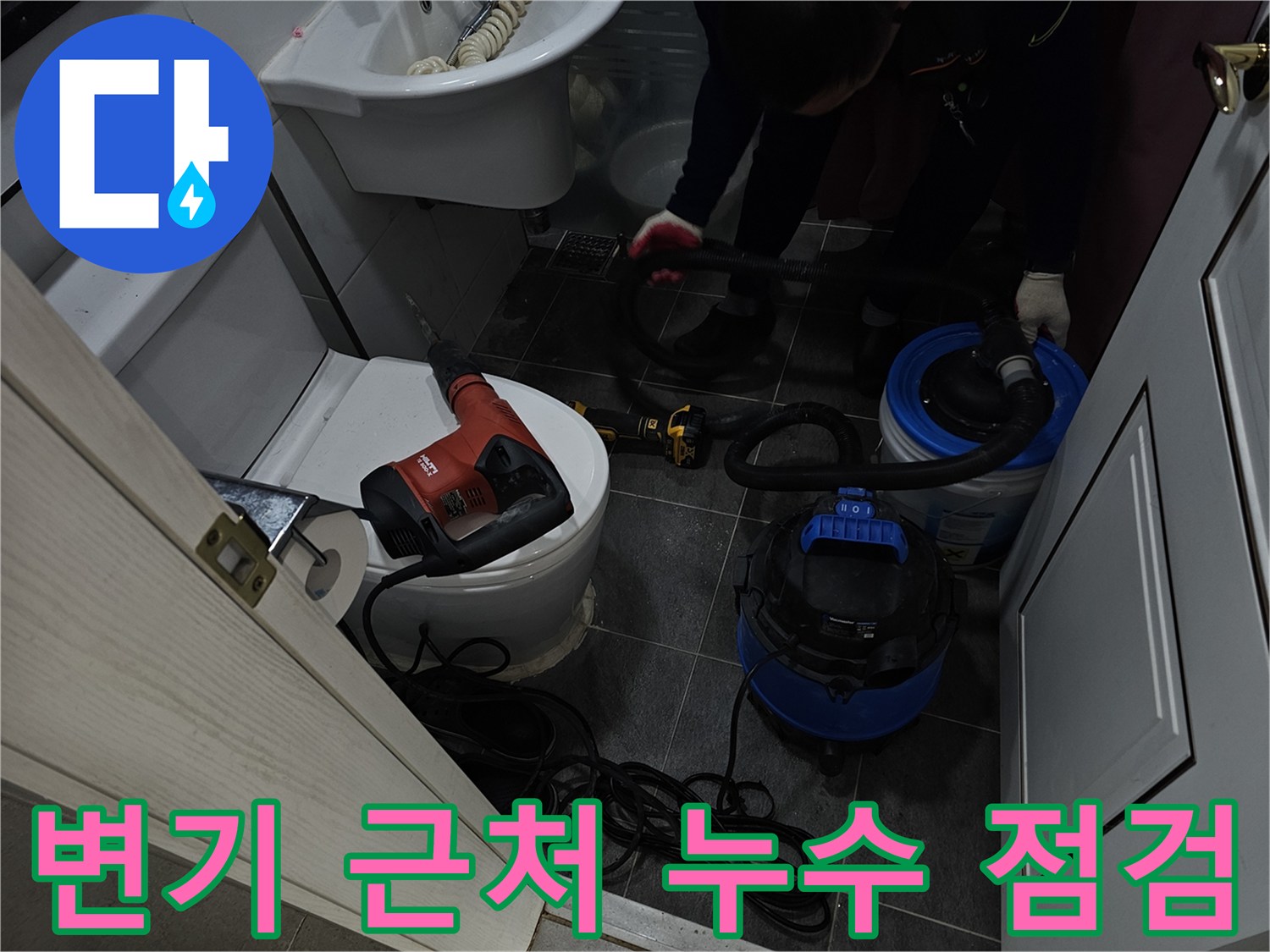 변기와 세면대 사이 바닥에서 진행되는 누수 진단 작업 모습