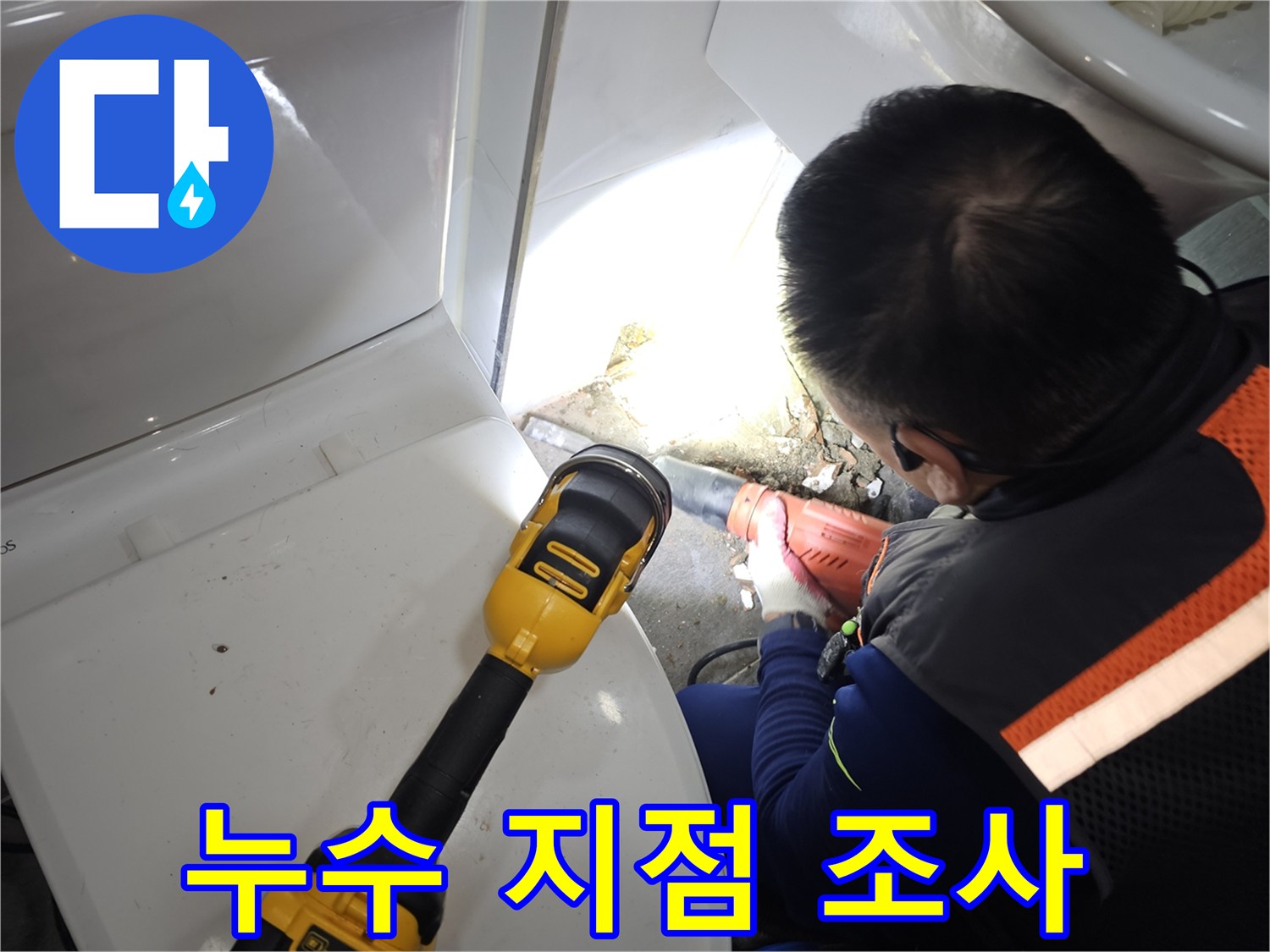 손전등으로 비춘 변기 뒤쪽 배관의 습한 상태 확인