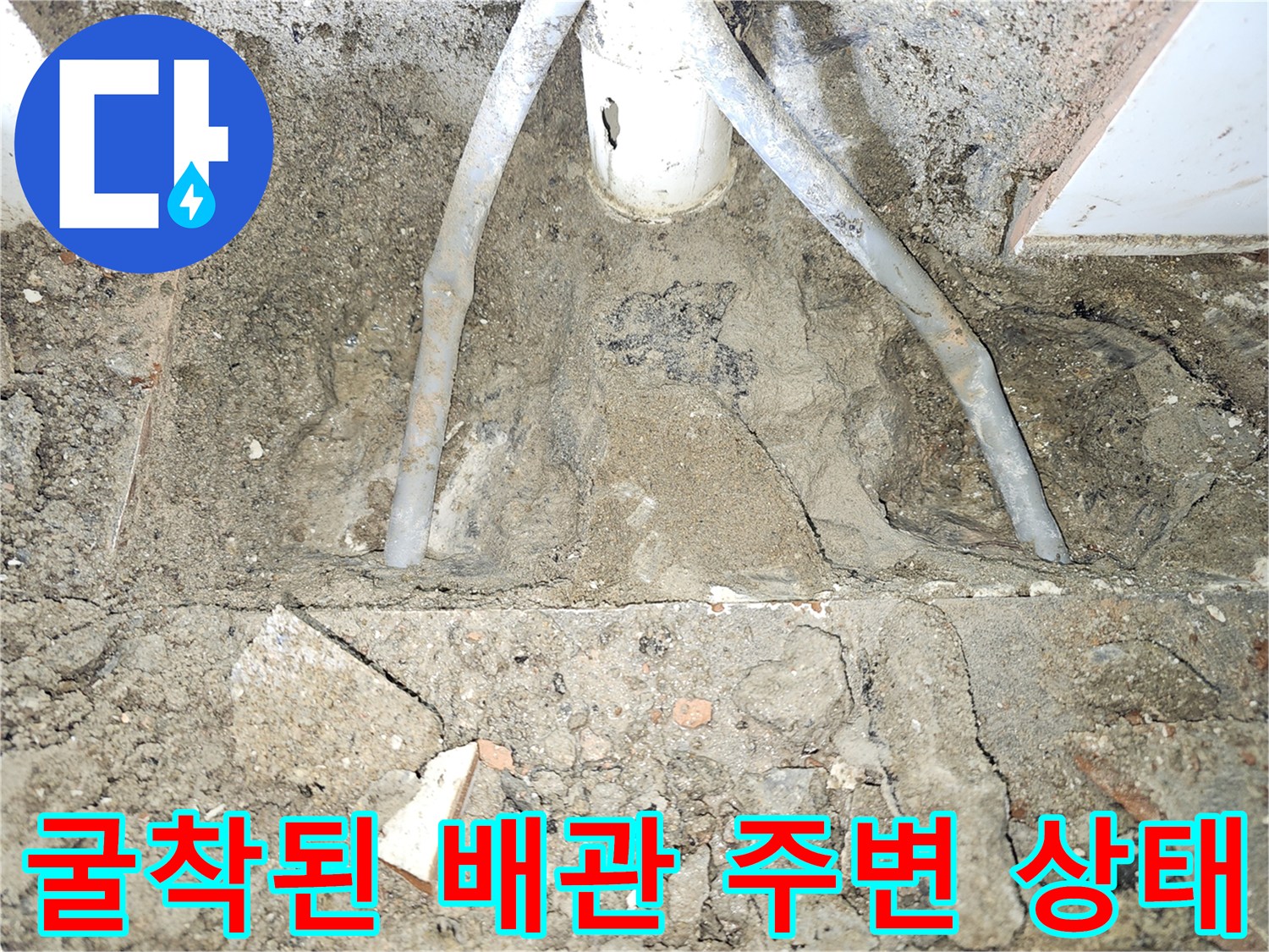 화장실 바닥 굴착을 통해 드러난 노출 배관과 젖은 흙의 모습