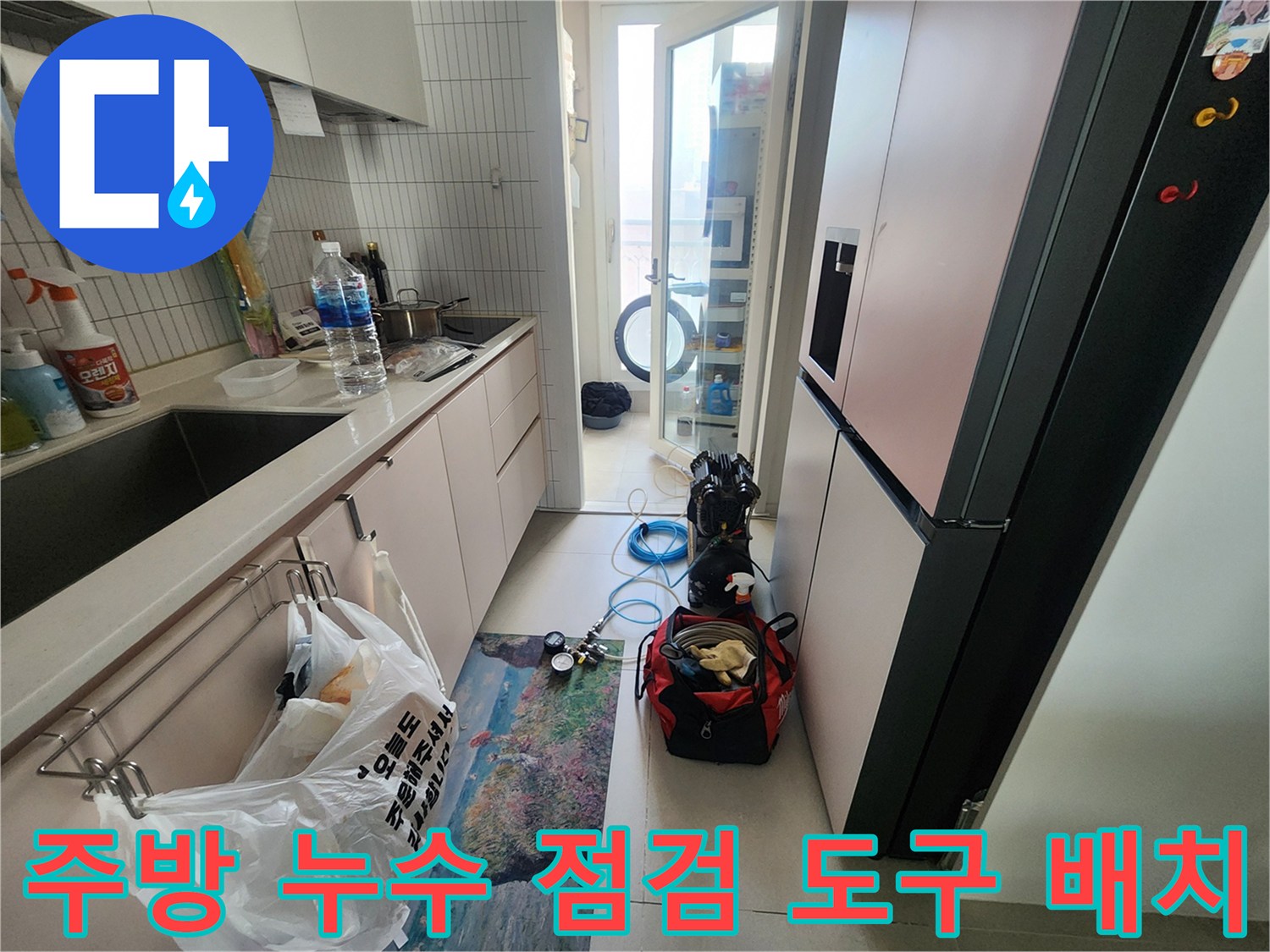 싱크대 밑 바닥에 놓인 압력 측정 장비와 작업용 공구 세트