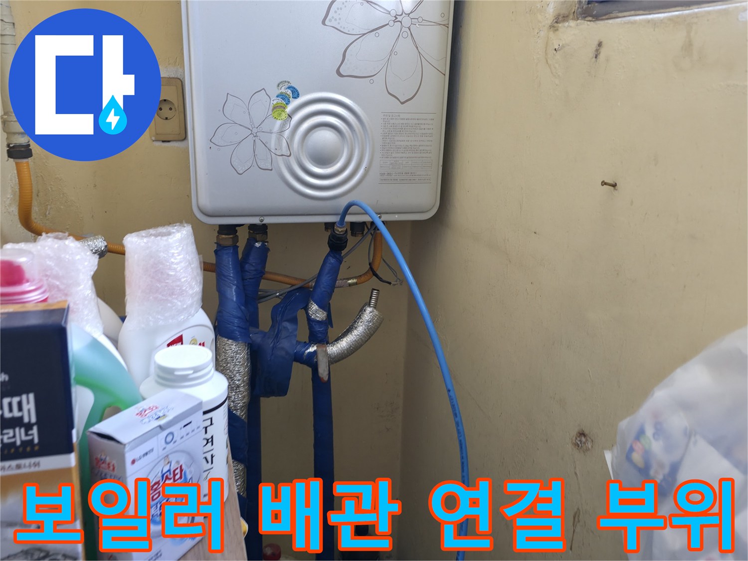 보일러 하단에 노출된 파란색 및 은색 배관의 모습