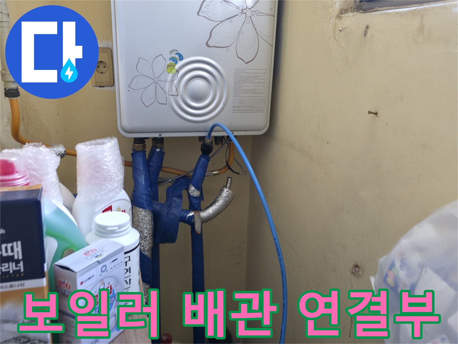 보일러실 하단에 연결된 파란색 배관과 보일러 본체 모습
