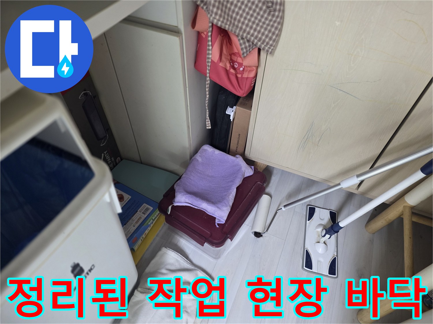 누수 지점을 찾기 위해 정리된 주방 바닥과 청소 도구 사진입니다.