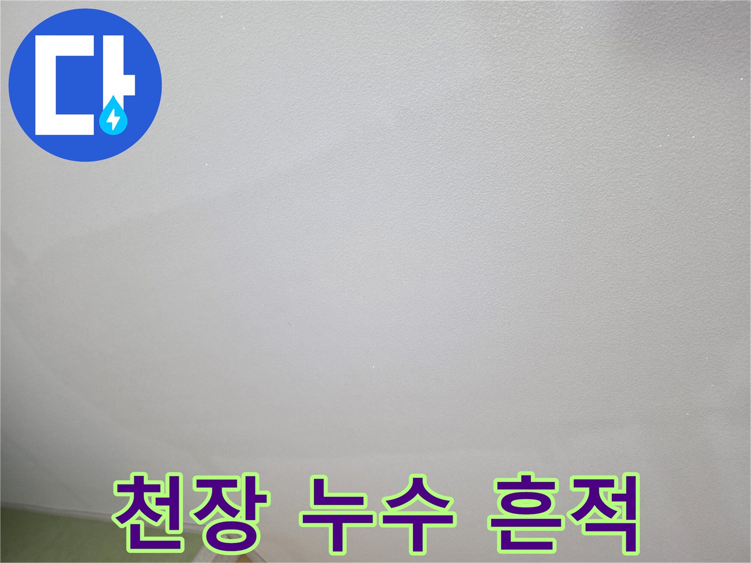 천장 도배지 표면에 나타난 넓은 얼룩과 습기 자국