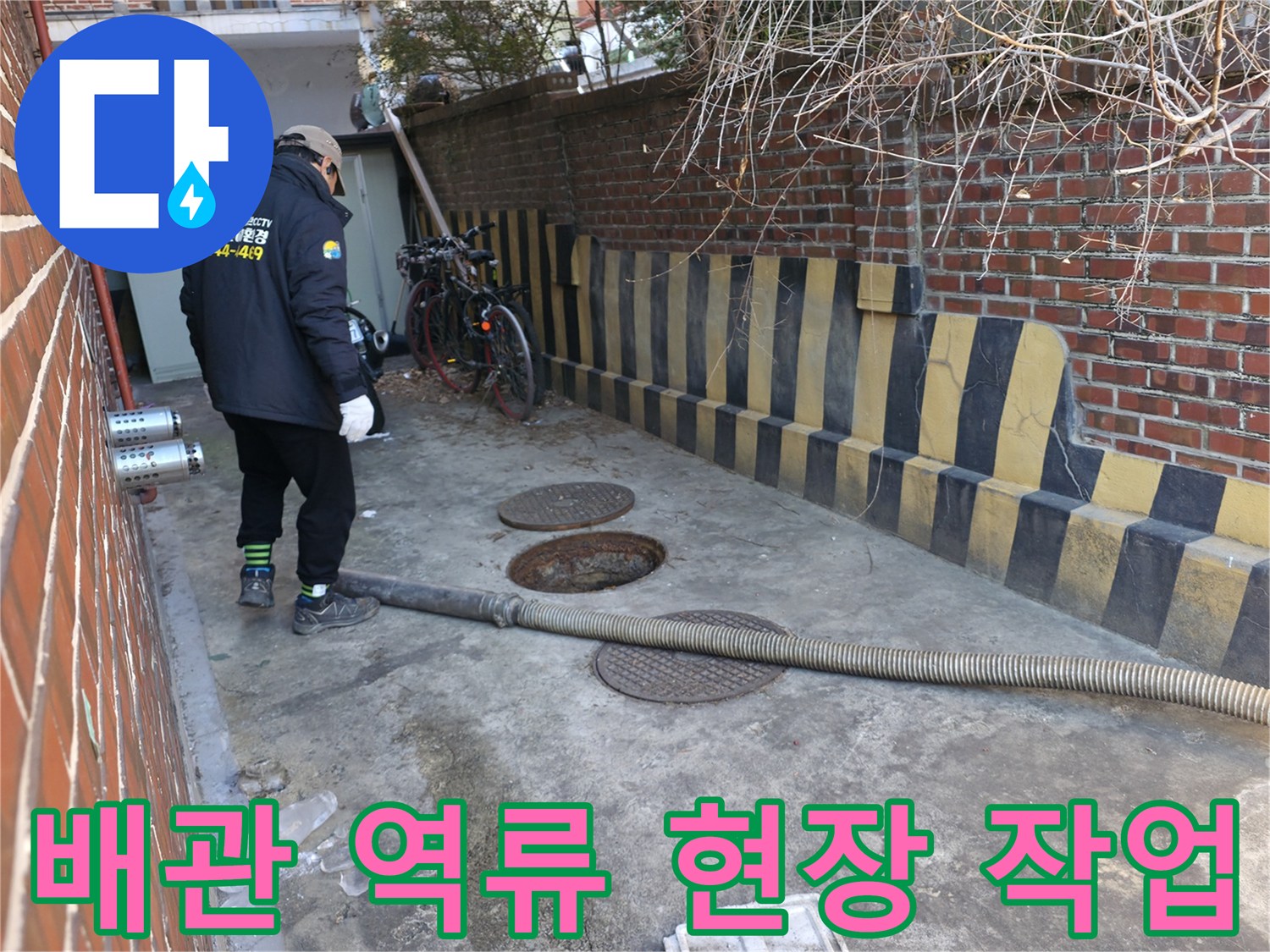 맨홀 주변의-하수관로 점검을 위해 장비를 배치한 엔지니어