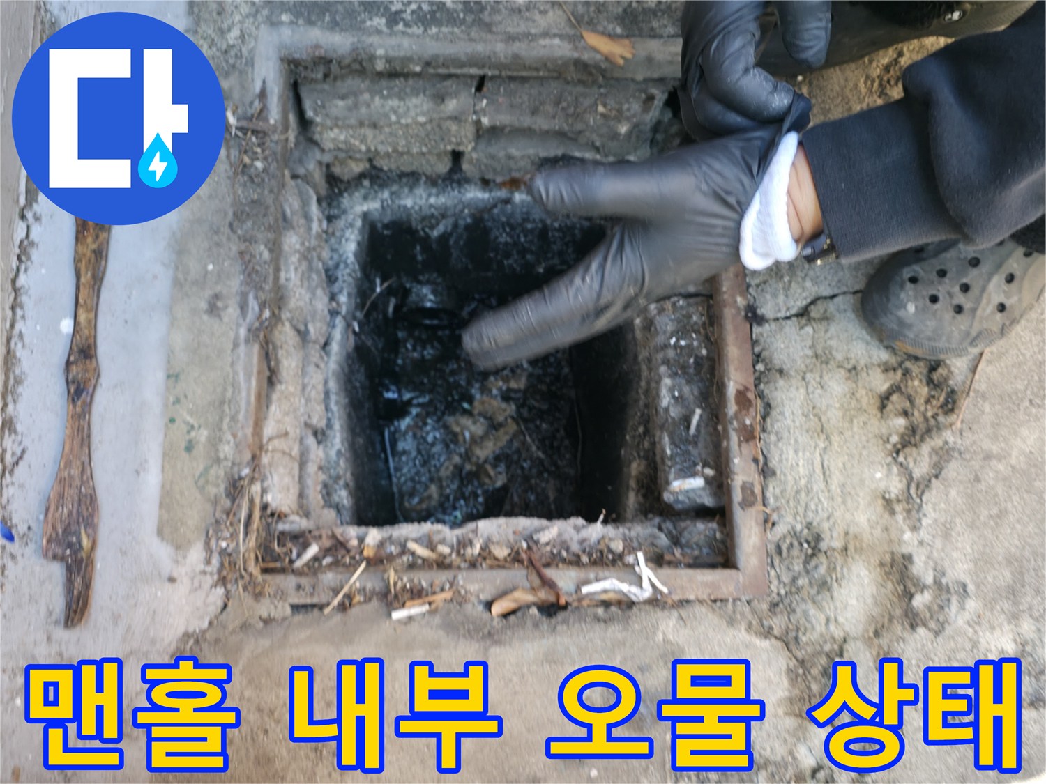 작업자가 맨홀 안쪽의 막힌 구간을 손으로 가리키며 점검하는 장면