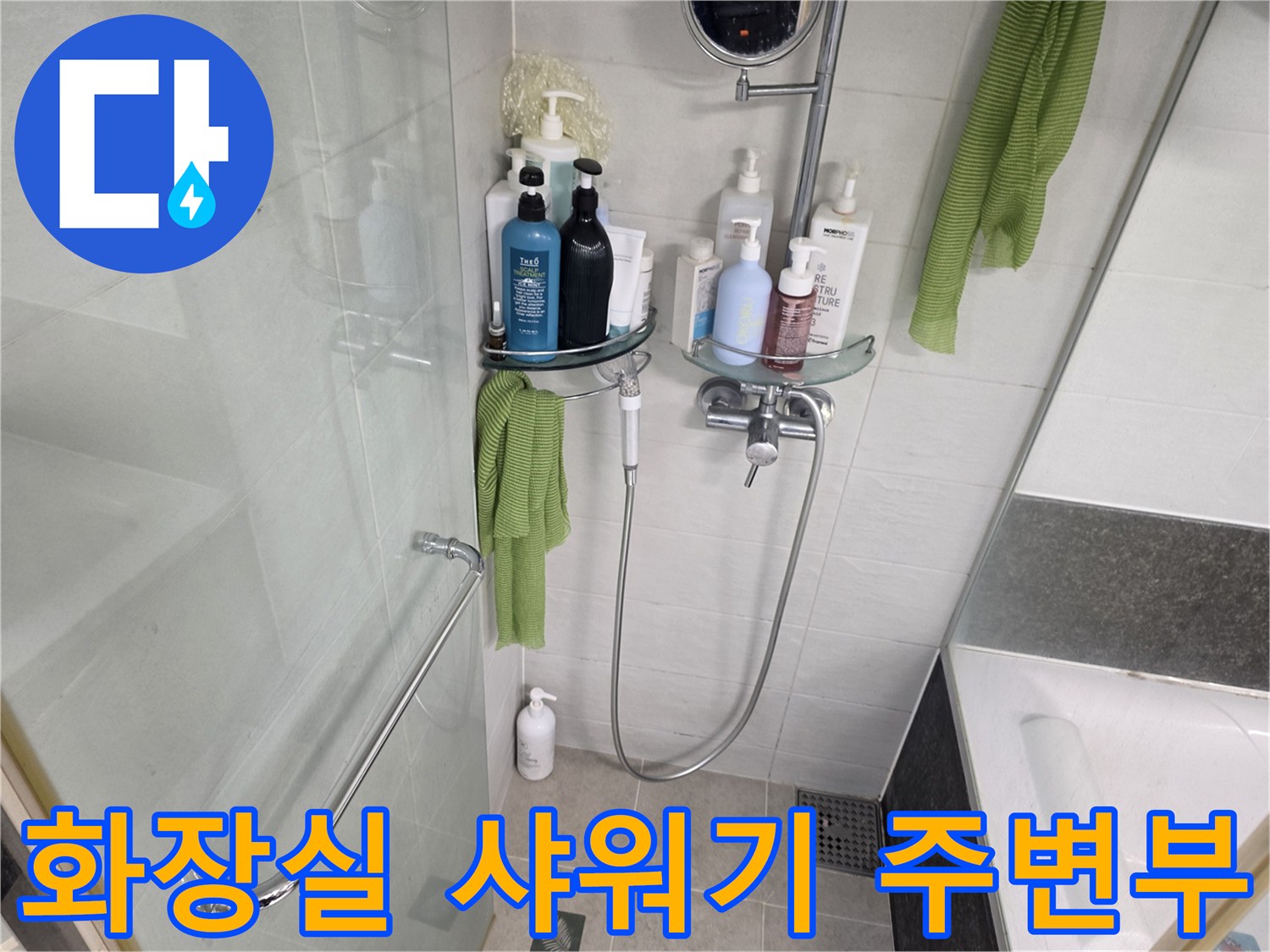 샤워기 수전과 벽면 선반이 설치된 화장실 내부 모습