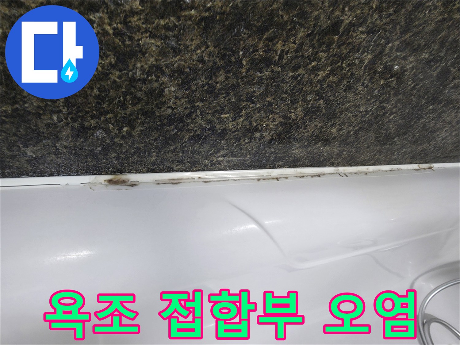 어두운 벽면과 흰 욕조 사이의 변색된 이음새 부위