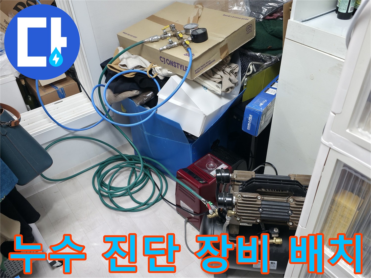 보일러실 바닥에 설치된 압력 테스트용 컴프레서와 연결 호스 모습