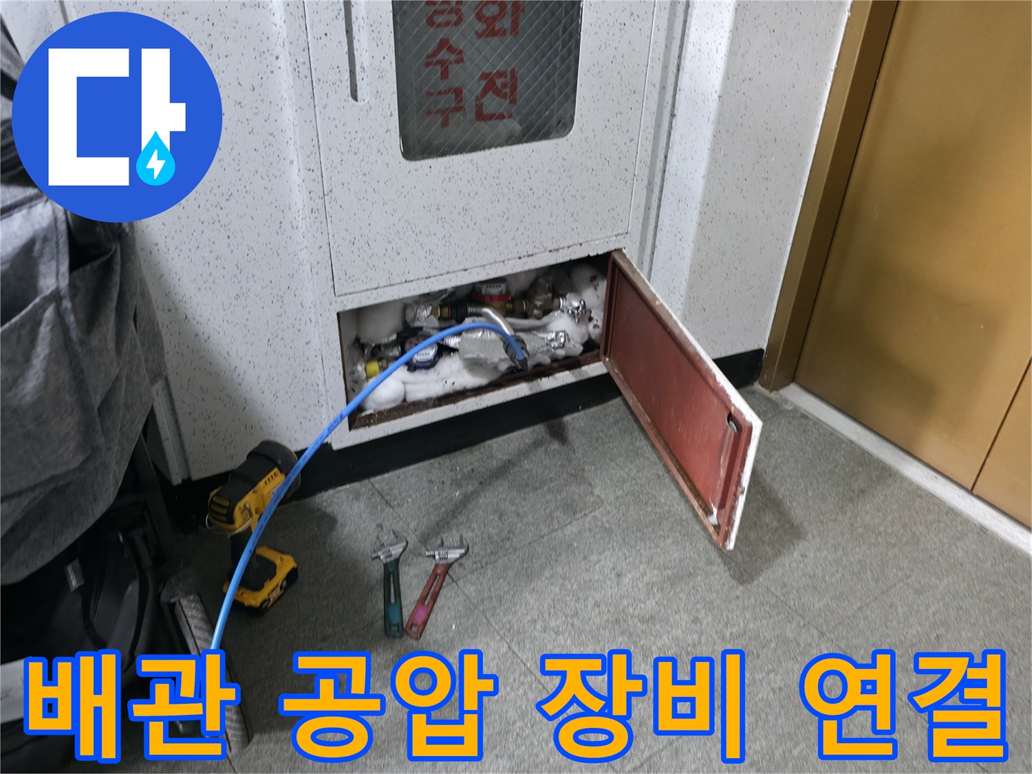 열린 점검구 사이로-배관 압력 테스트를 위한 호스가 보입니다.