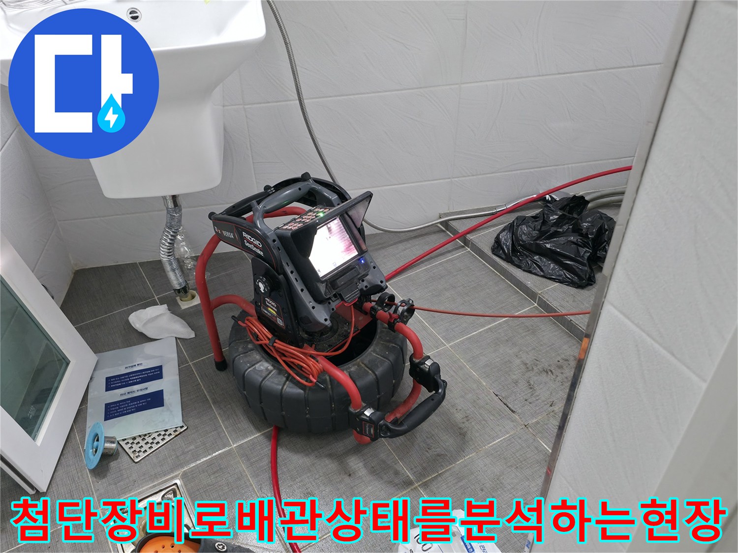 화장실 내부에서 배관 내시경 및 청음 장비를 사용하여 누수 지점을 분석하는 모습