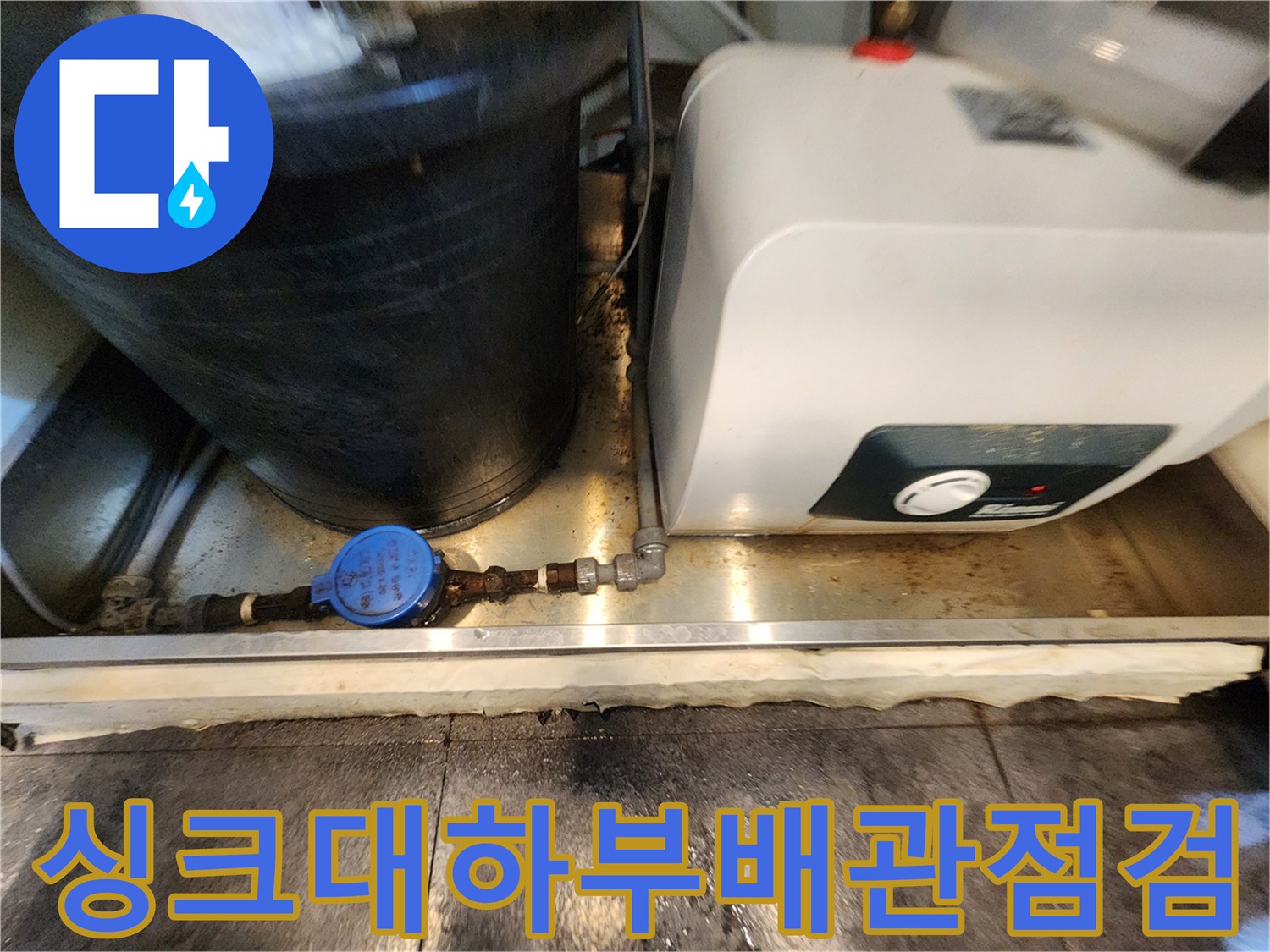 서초구 주방 싱크대 아래 온수기와 배관 주변의 물고임 상태를 확인하는 모습