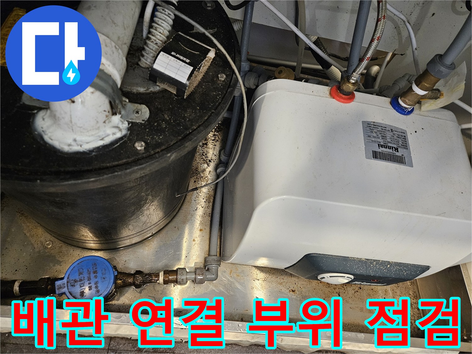 싱크대 하단 배관의 연결 부위와 계량기 근처의 습한 상태를 나타냅니다.