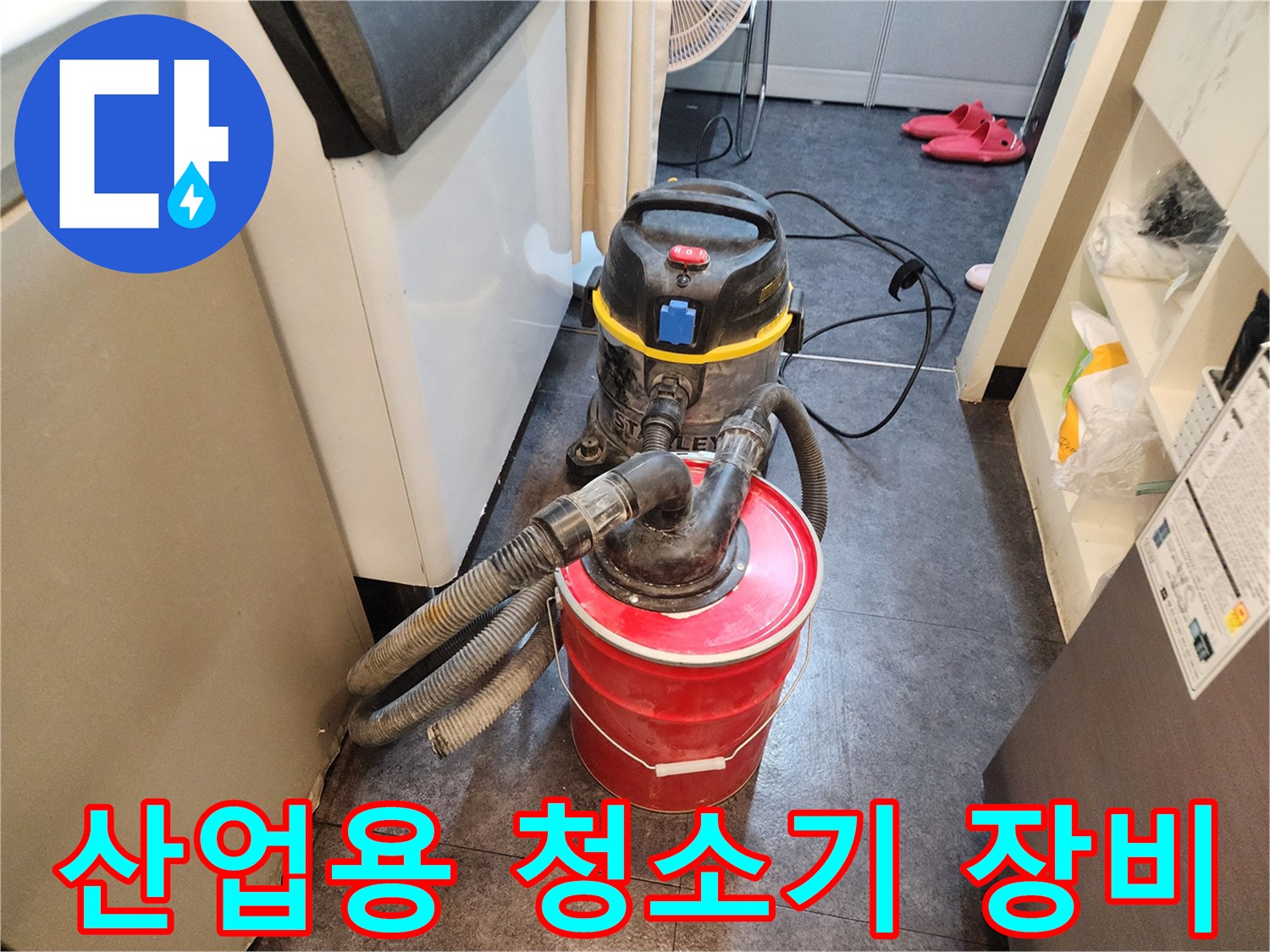 현장의 오염물과 물기를 흡입하기 위해 사용 중인 산업용 진공 청소기