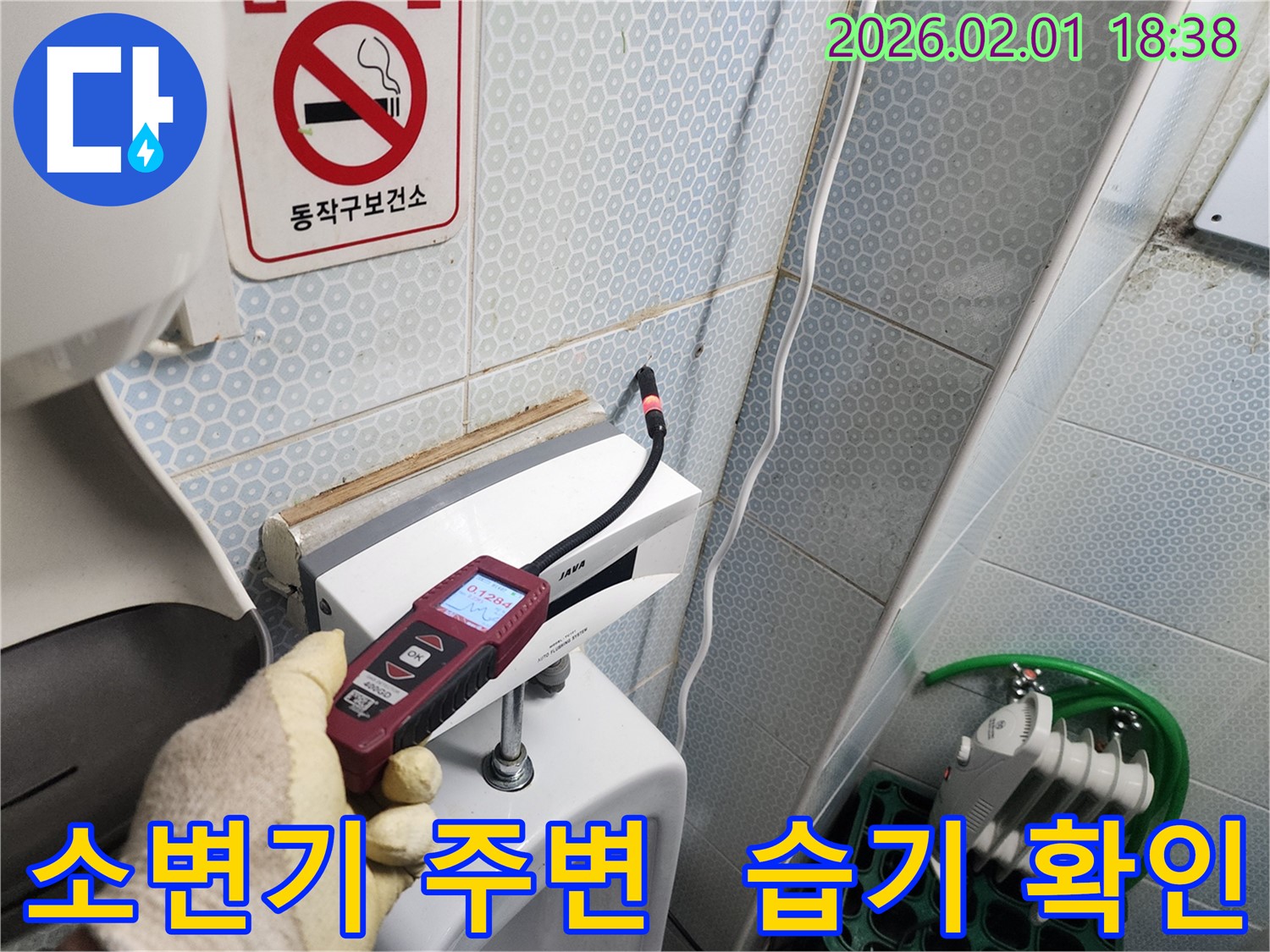 흑석동 누수 현장에서 소변기 주변 습기를 확인하는 모습 - 습기는 누수의 신호일 수 있습니다.