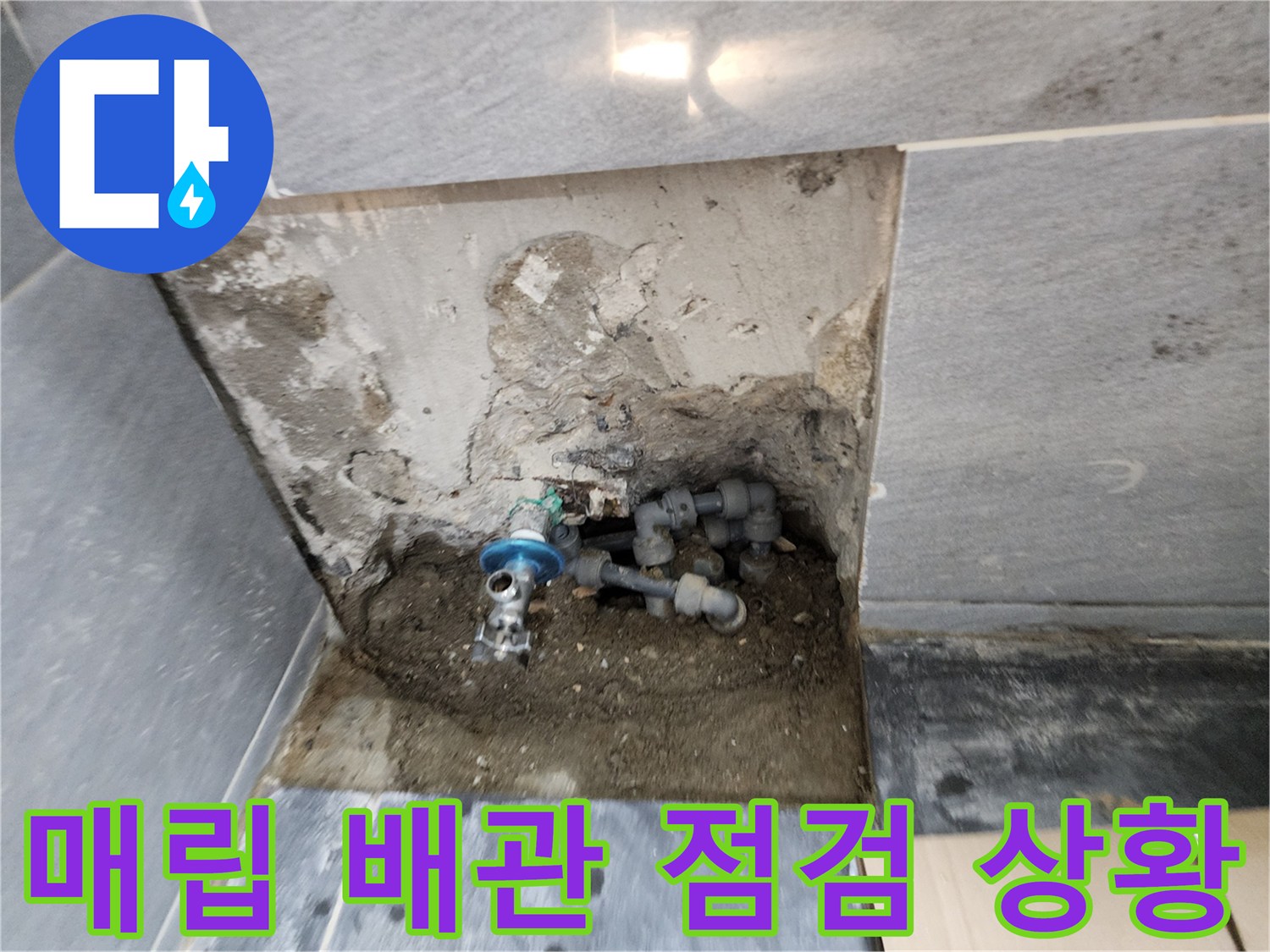 벽면 굴착을 통해 드러난 변기 연결 배관과 주변의 습한 상태를 나타냅니다.