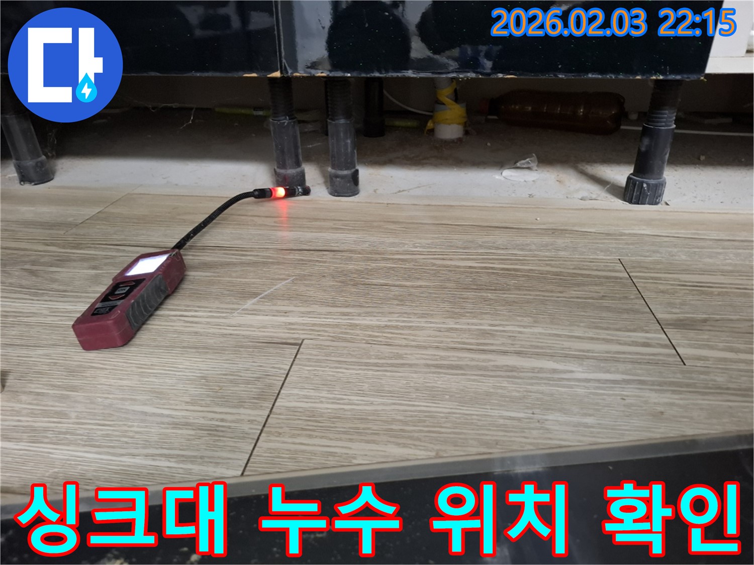 싱크대 아래에서 누수 탐지 장비로 누수 위치를 확인하는 모습 - 꼼꼼하게 확인하여 문제 해결!