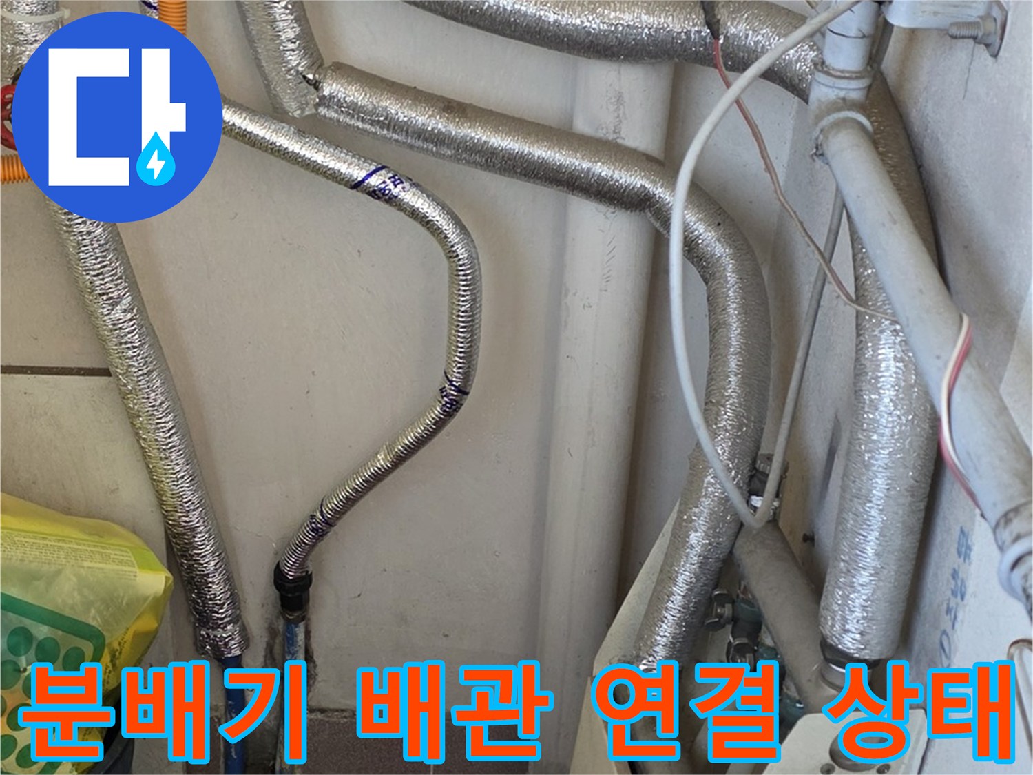 보일러 분배기와 연결된 은색 보온재 배관의 모습입니다.