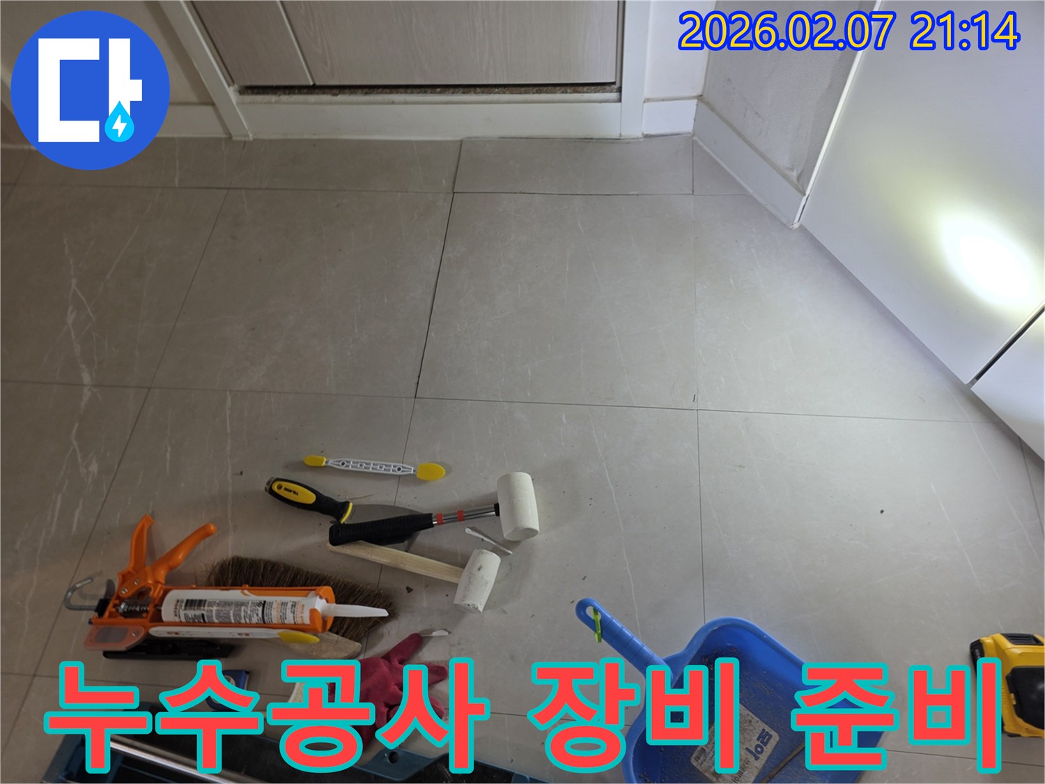 누수-현장에서-사용될-다양한-공구와-재료들이-타일-바닥에-정돈되어-있는-작업-시작-전-모습입니다