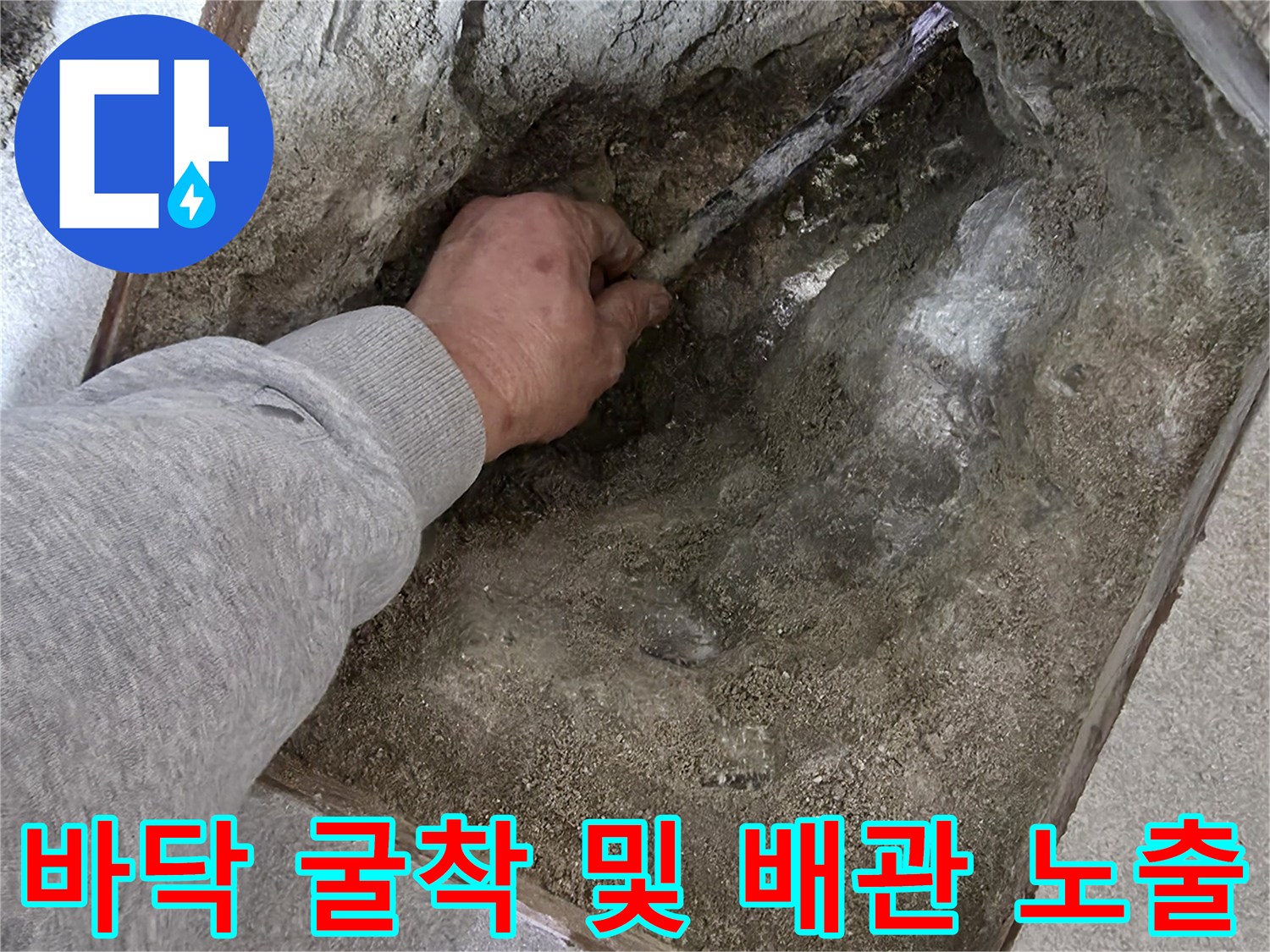 손으로 배관 주변의 흙과 시멘트를 정리하며 누수 지점을 찾는 모습