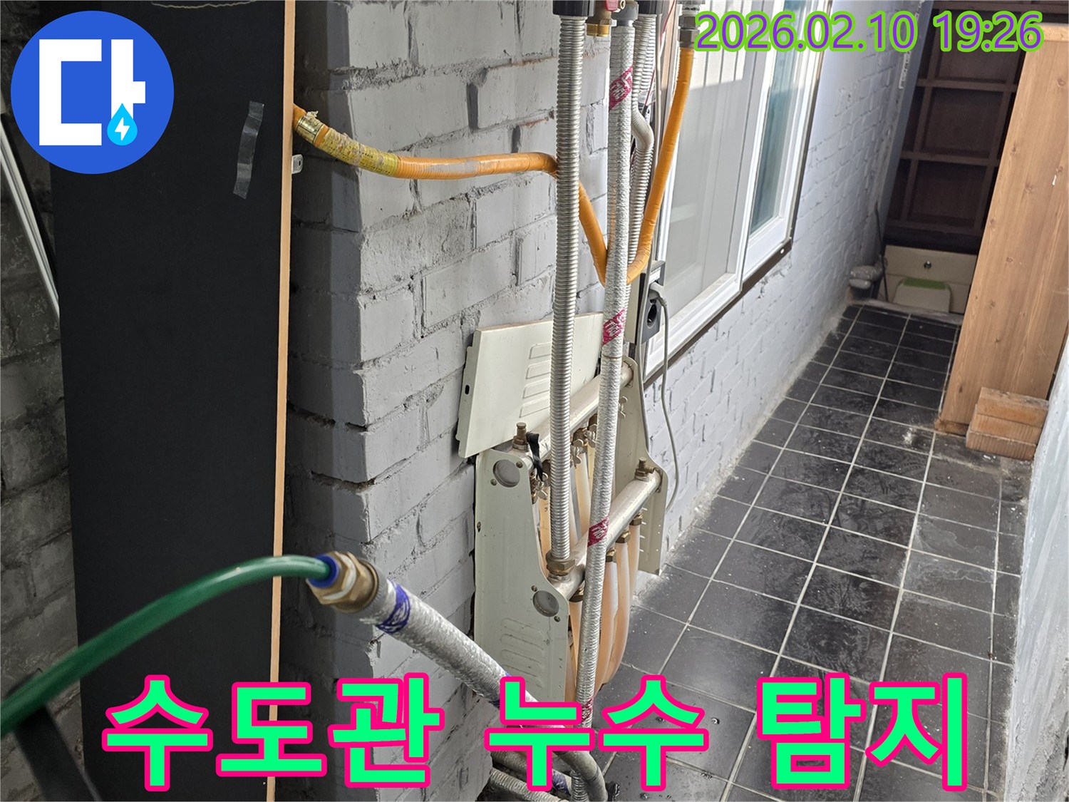 상가 건물 외부에서 수도관 누수 탐지를 위해-배관 연결 상태를 확인하는 작업