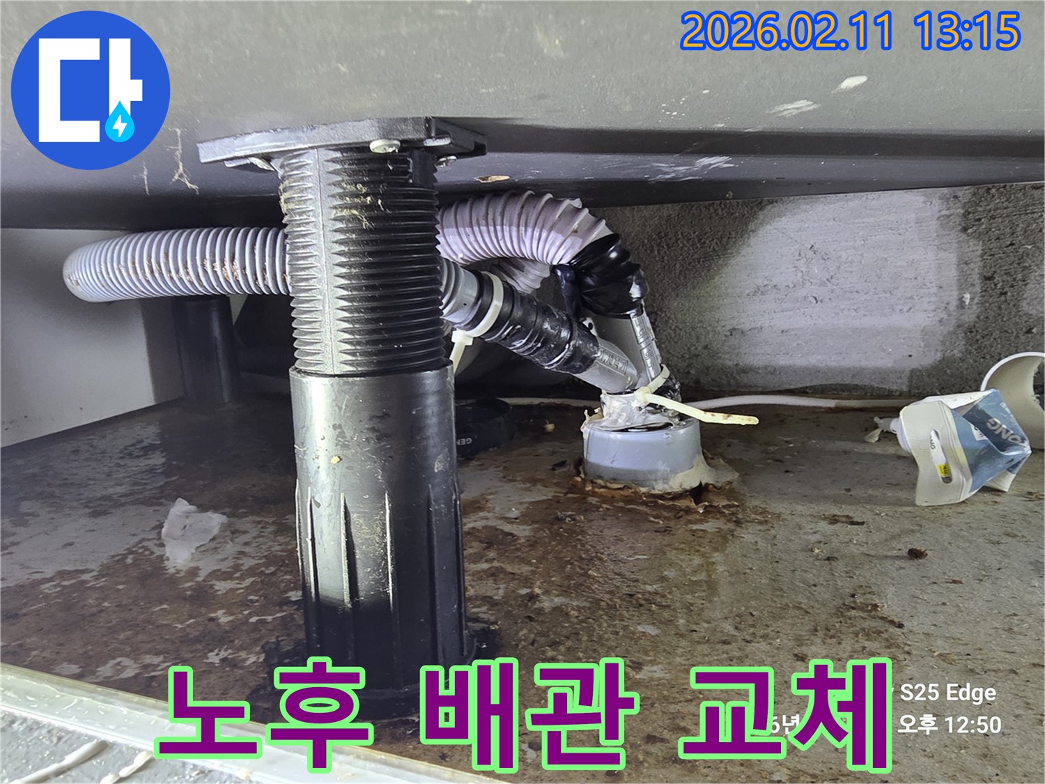 싱크대 하부 배수관의-노후화된 연결부에서-물이 새어 나온 현장을 촬영한 이미지입니다.