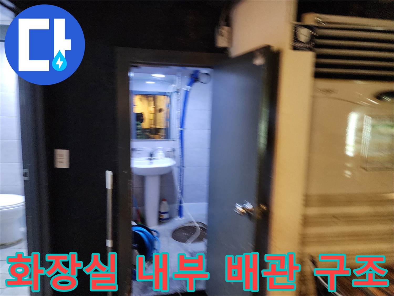 벽면에 설치된 파란색 주름관과 바닥 배수구 주변의 모습입니다.