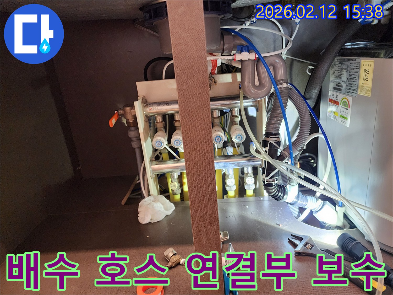 서초구 빌라의-배수 호스 연결부에서-누수 여부를 점검하고-보수하는 작업 현장입니다.