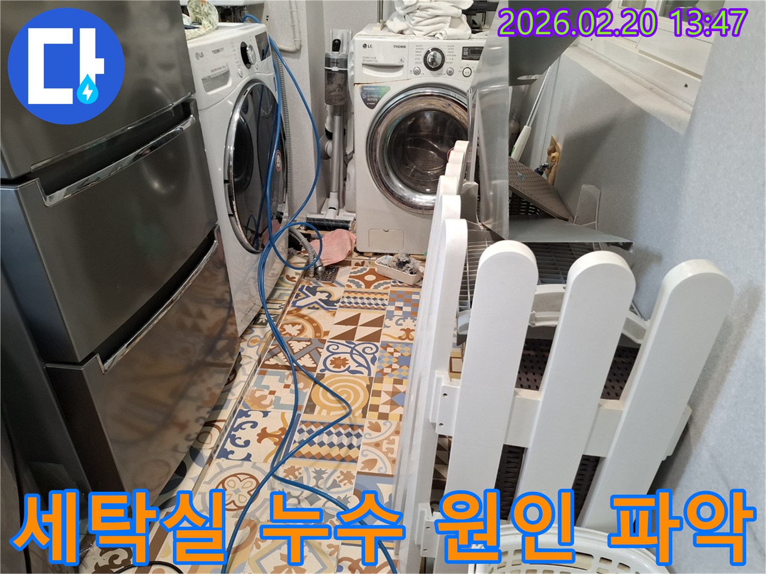 세탁실 바닥에 누수 탐지 장비 호스가 설치되어 있고-누수 원인을 파악하기 위해 엔지니어가 작업 중인 현장입니다.