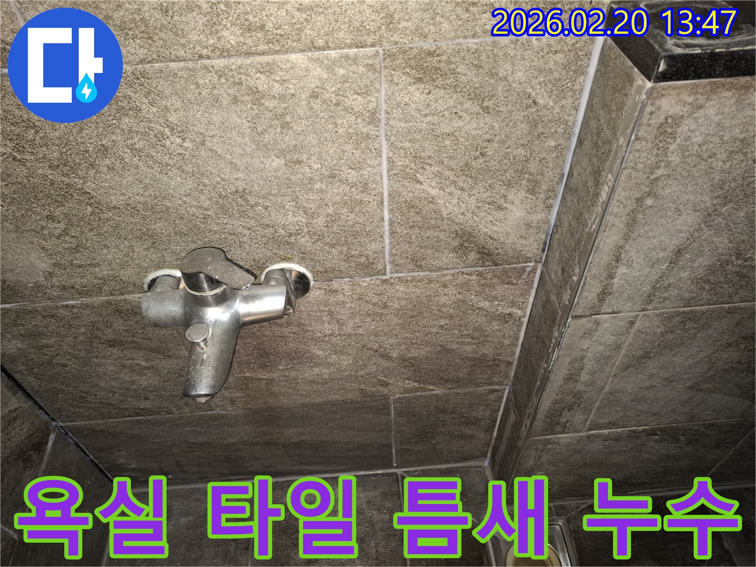 욕실 벽면 타일의 미세한 틈새와-수전 주변의 상태를-물이 스며드는 현상과 관련하여 정밀하게 점검하는 모습