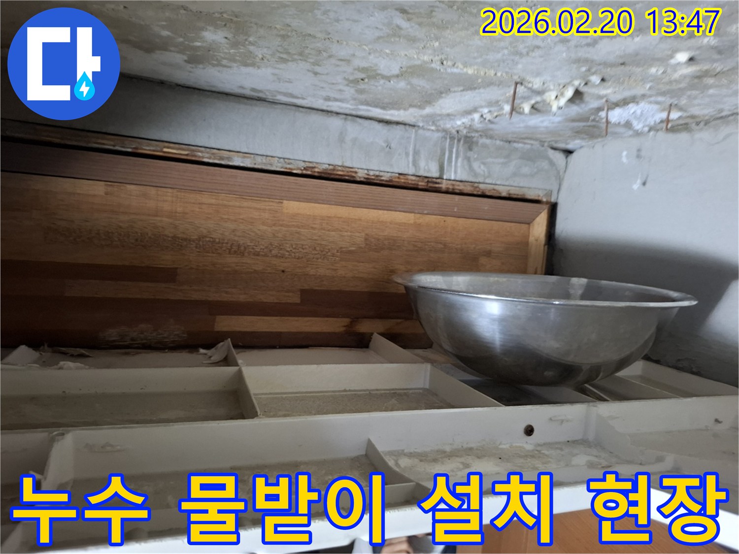 천장에서 물이 떨어져-임시로 물을 받고 있는-누수 현장의 모습이 담긴 사진입니다