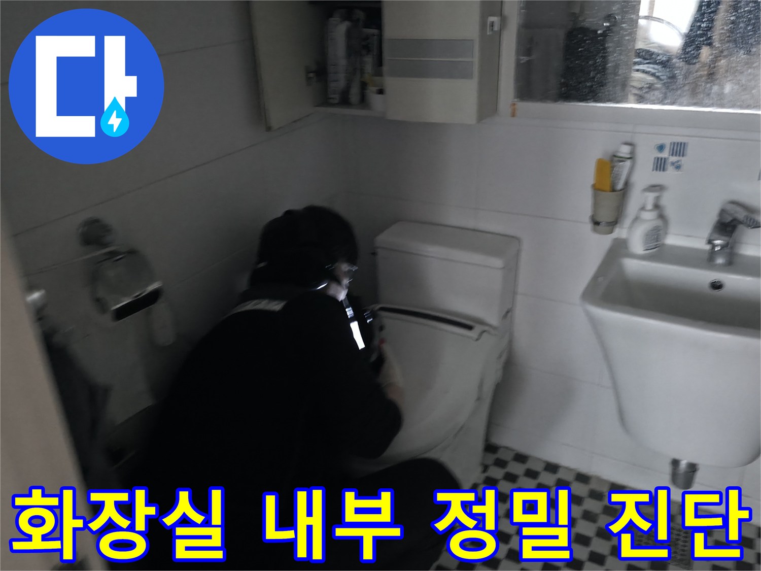 작업자가 화장실 내 세면대와 변기 주변을 집중적으로 점검하고 있습니다.
