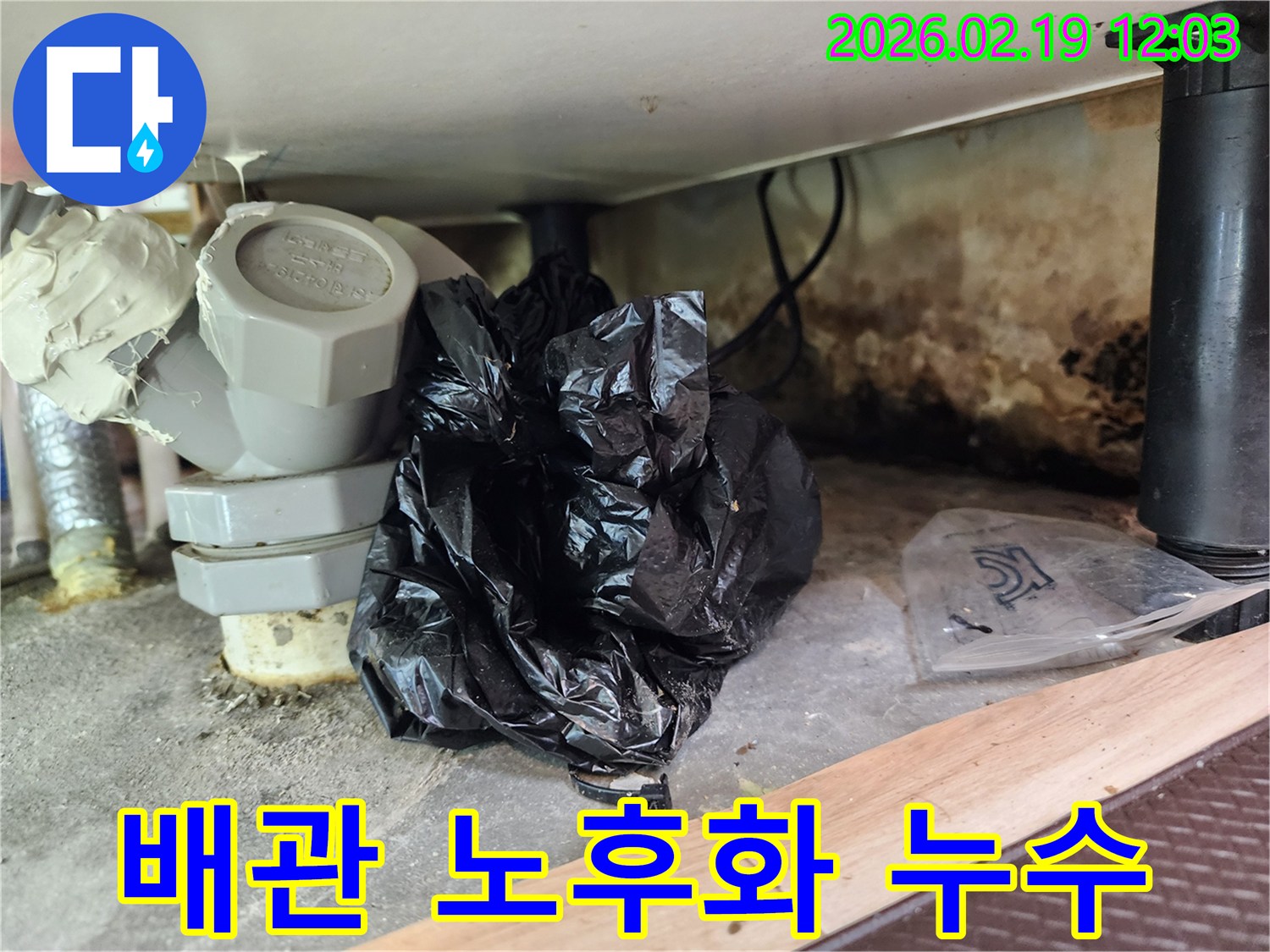 이 이미지는 낡은 배관 부속과-주변의 곰팡이-그리고 누수로 인한 오염 상태를 보여줍니다.
