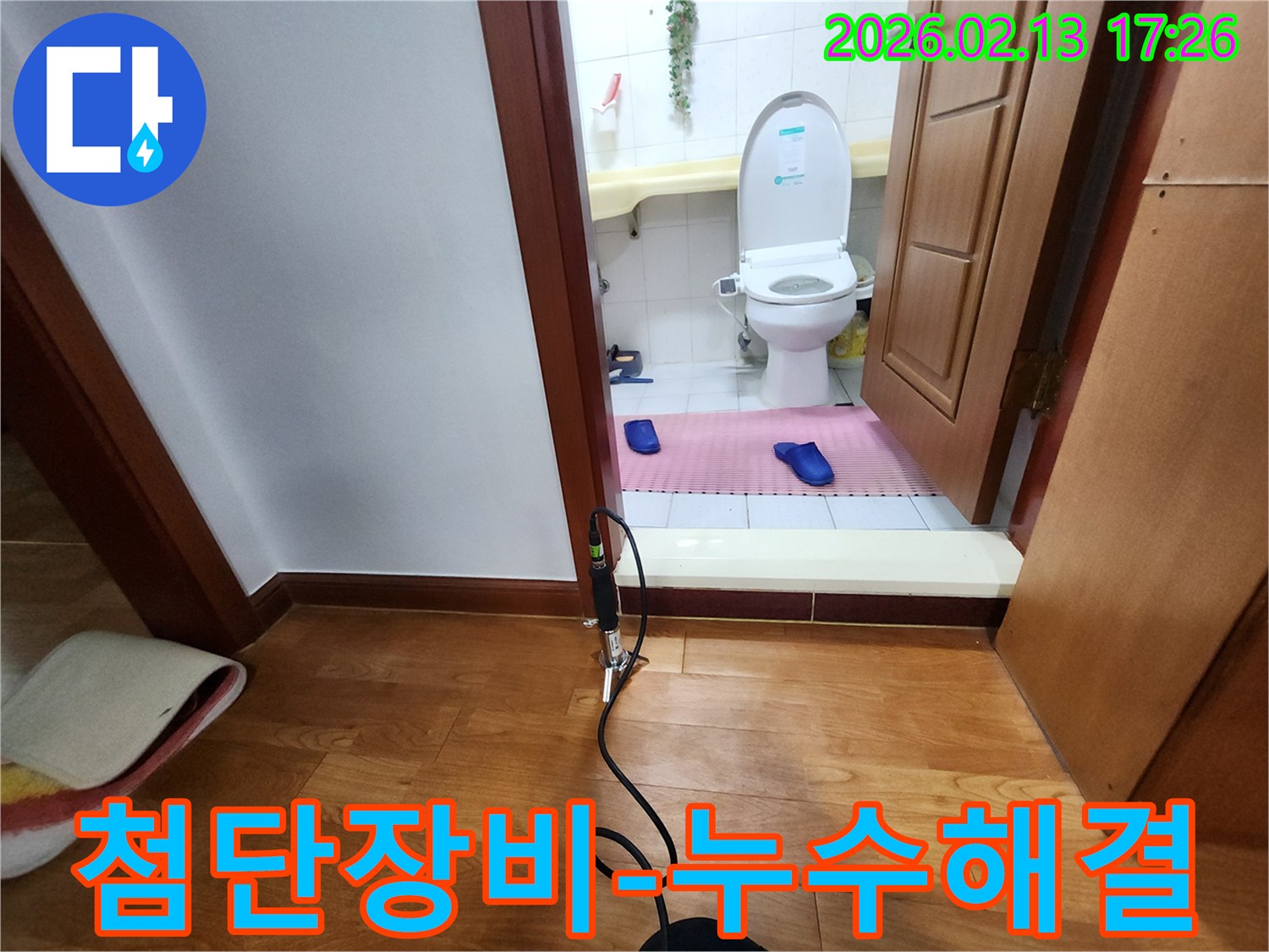 화장실 입구에 설치된 첨단 누수 탐지 장비로 배관 누수 문제를 해결하기 위한 정밀 작업