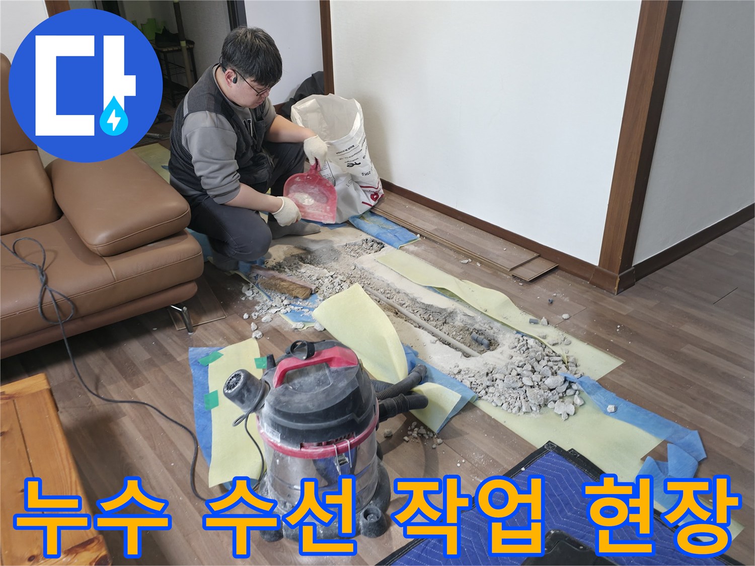 청소기를 사용하여 굴착 부위의 먼지와 잔해를 정리하며 배관 수선을 준비하는 모습입니다.