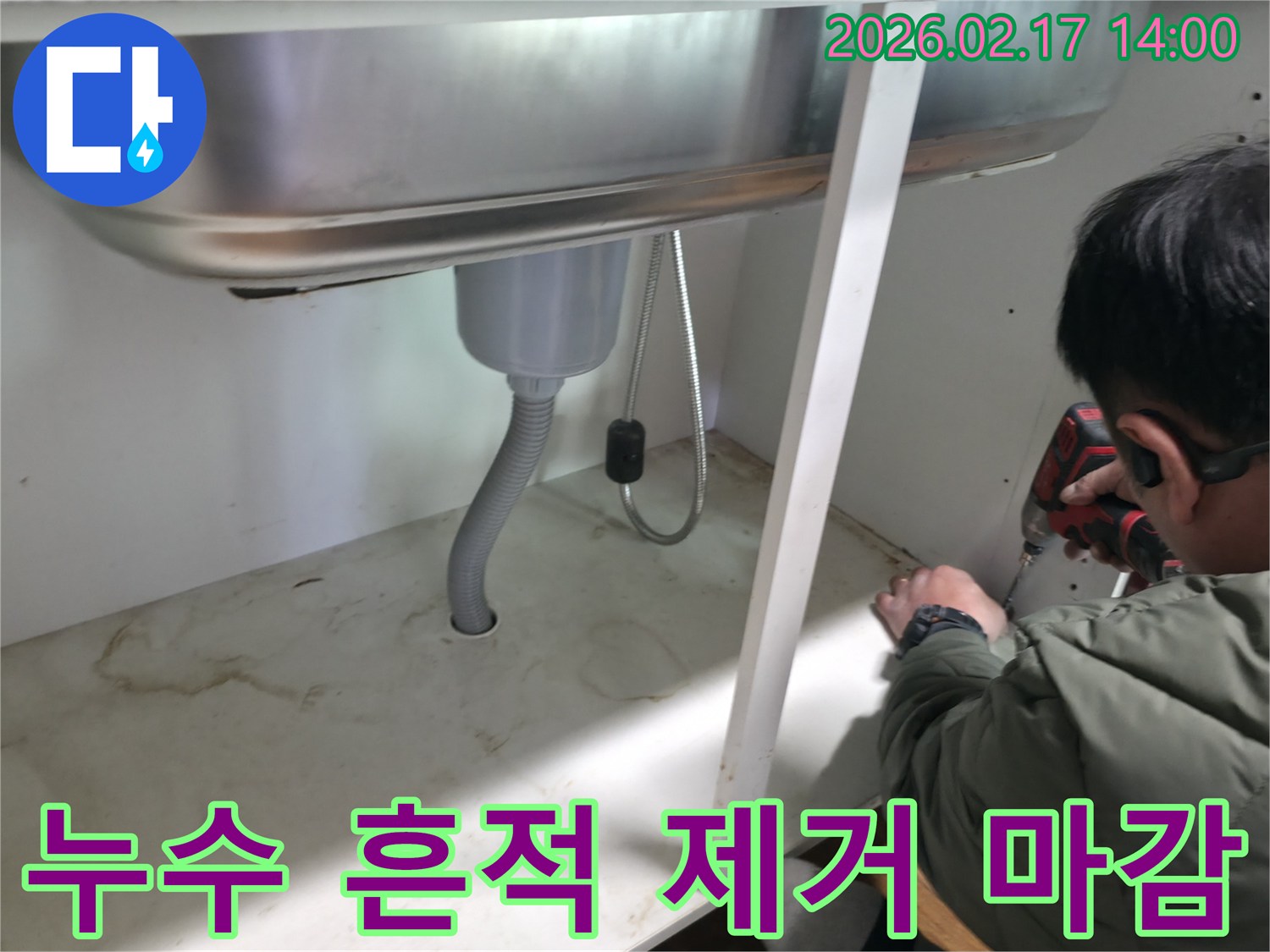 싱크대 하부 바닥에 남아있던-누수 흔적을 깨끗하게 제거하고-마감 작업을 진행하는 전문가