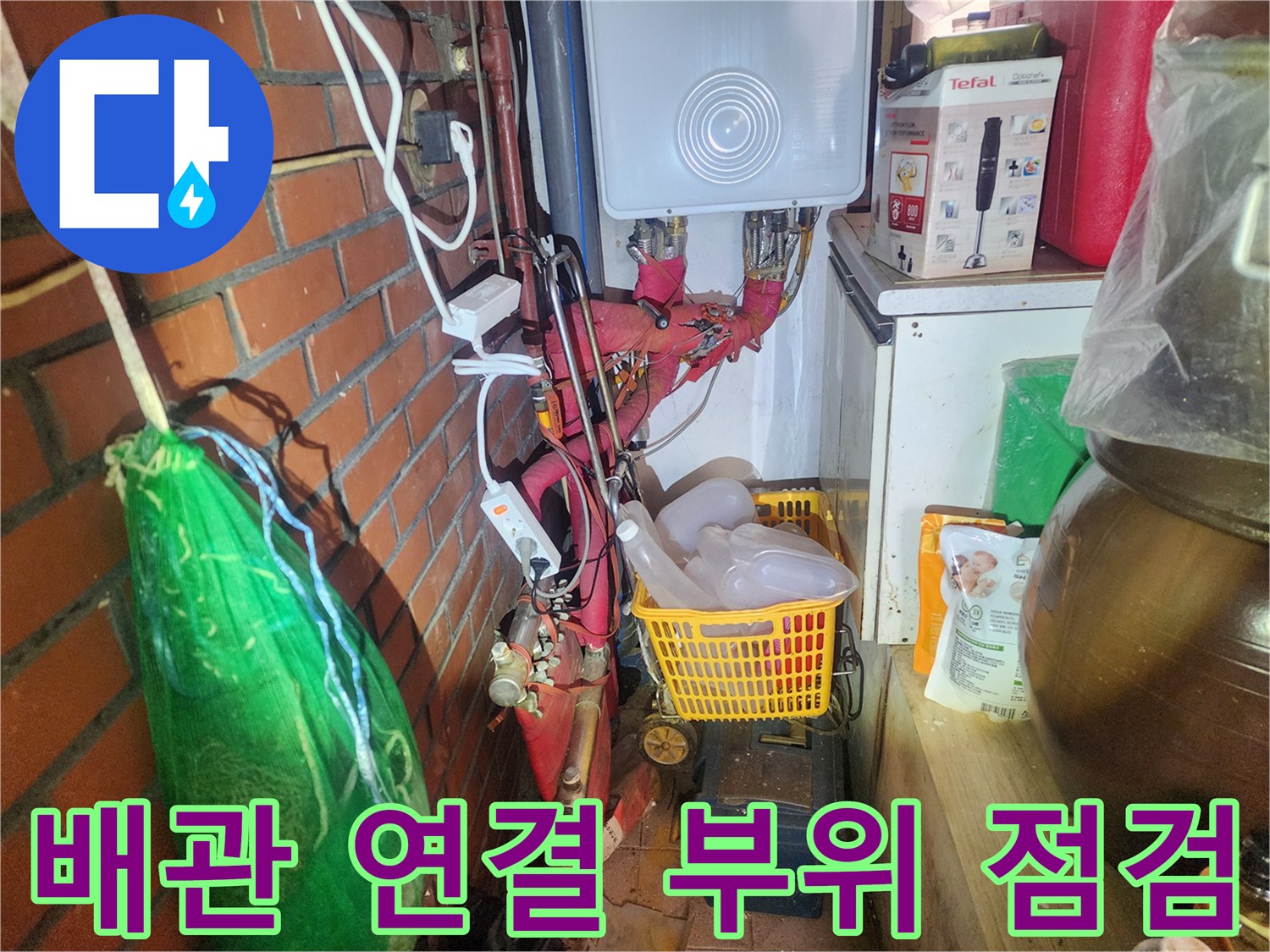 붉은색 보온재가 씌워진-노후된 배관과 금속 밸브의 근접 촬영