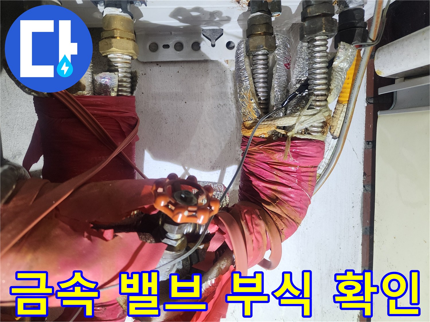 붉은색 보온재와-부식된 금속 배관 연결부의 모습