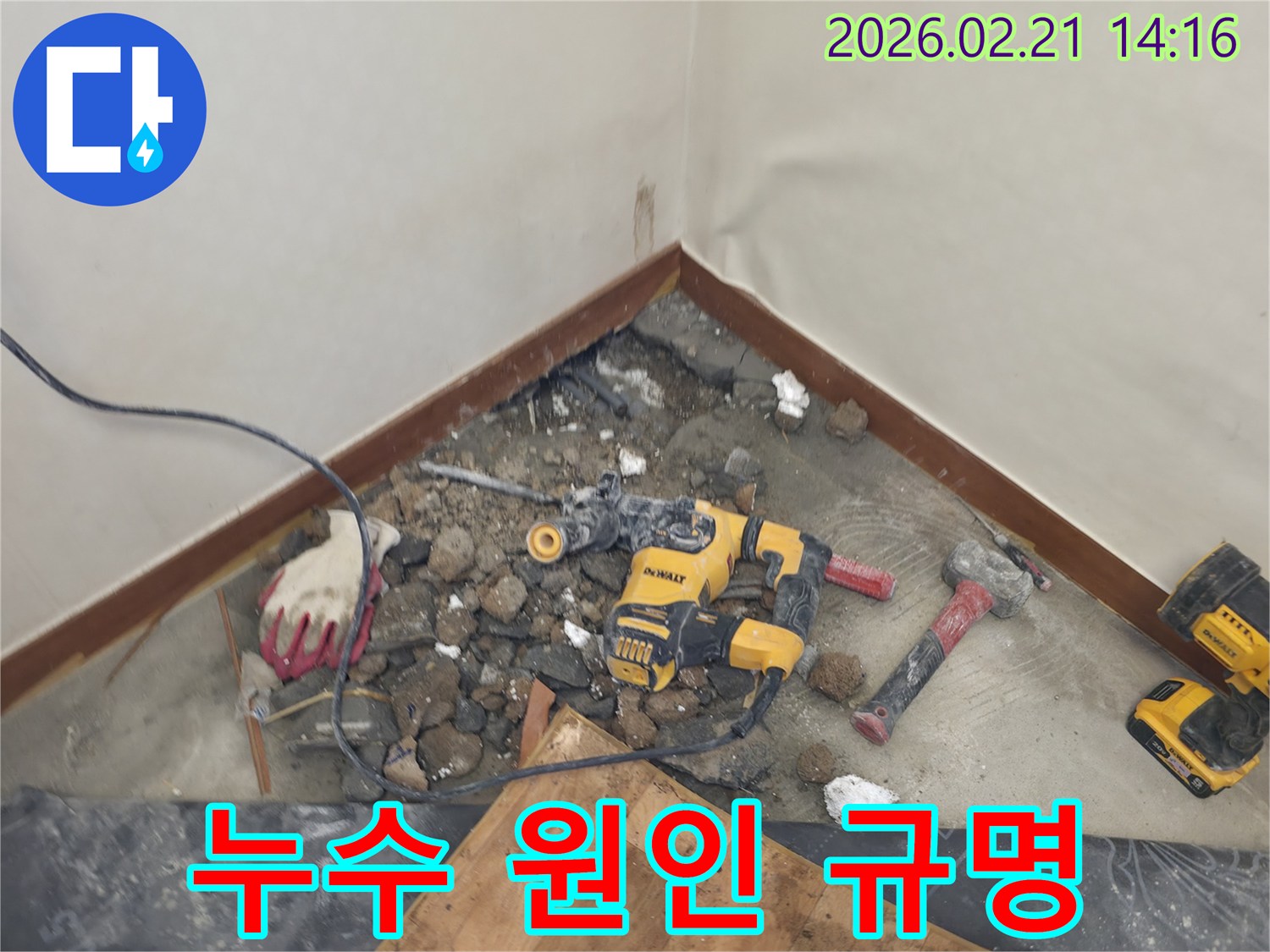 누수 원인을 파악하기 위해 바닥을 파쇄하고 있는 공사 현장-안전 장비가 함께 보입니다