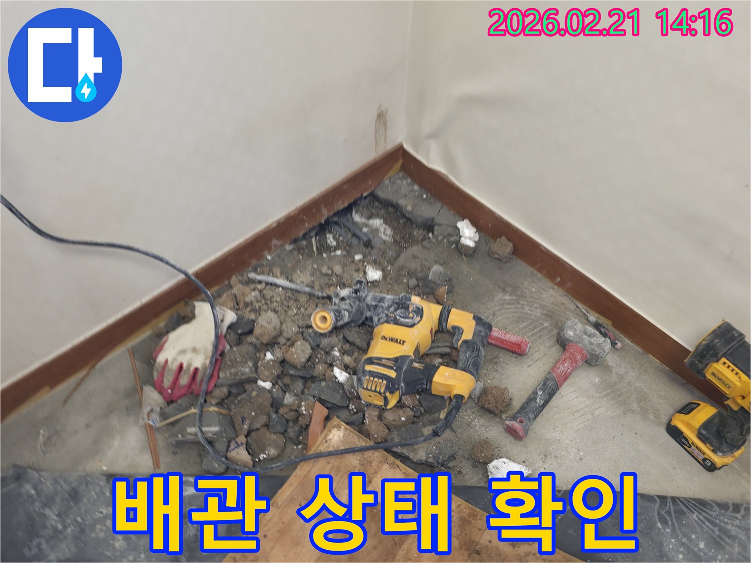누수 지점을 찾아 바닥을 파쇄하고 배관을 점검하는 현장-전문 공구가 놓여있습니다