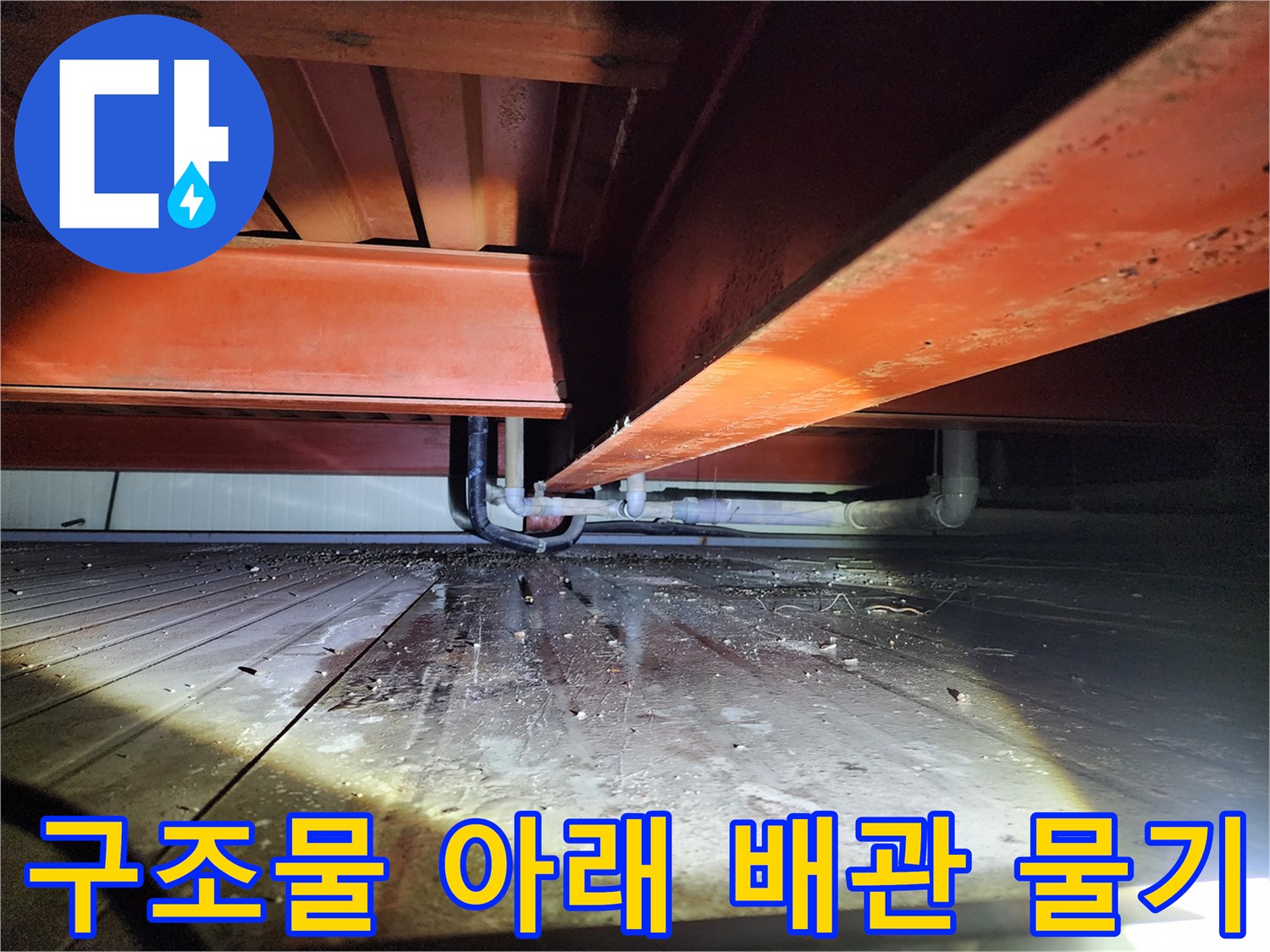 천장 배관 주변 바닥에 맺힌 물기와 습한 상태를 보여주는 사진입니다.