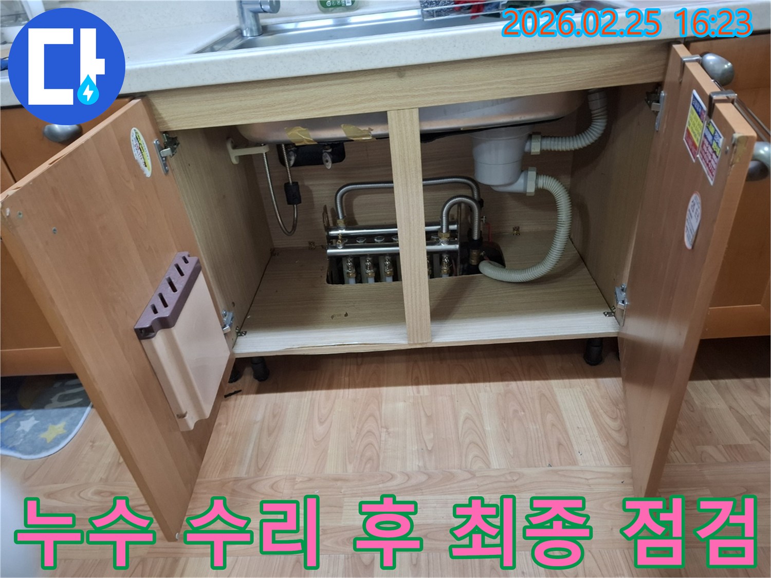 이 이미지는-김포 감정동 주택의-싱크대 하부장 누수 수리 후-재발 방지를 위해-최종적으로 점검하는-과정을 보여주고 있습니다