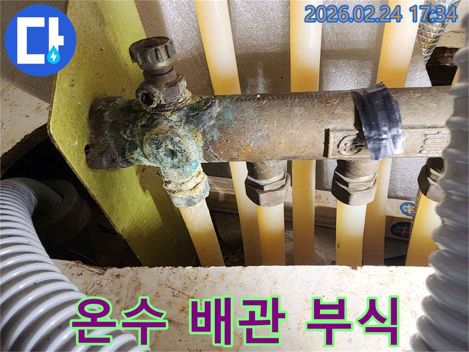 이 이미지는 주택 온수 배관 분배기의 밸브에서-발생한 심각한 부식과-그로 인한 누수 현장을 보여주며-완벽한 수리가 필요함을 나타냅니다.